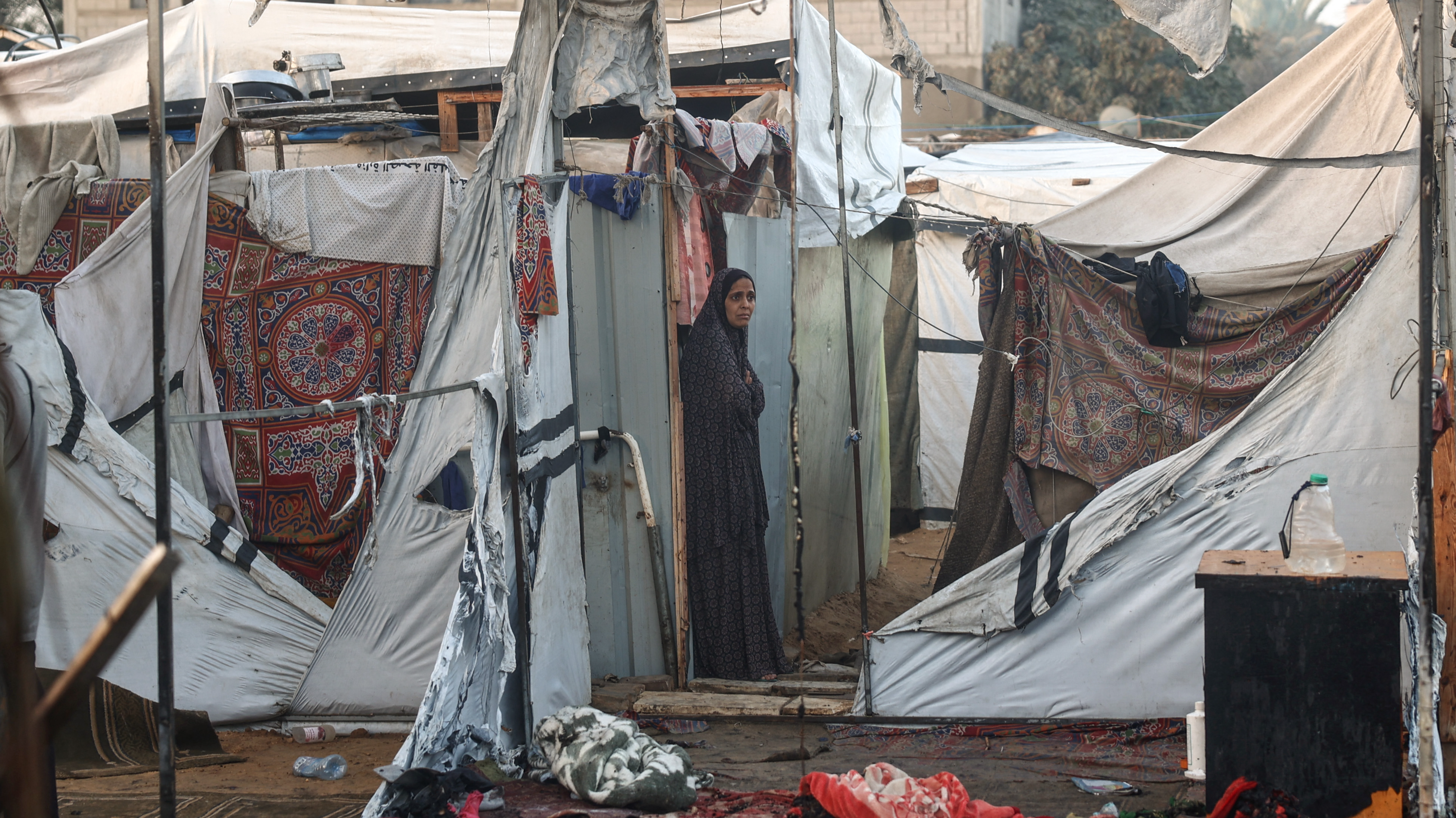 A Palestinian woman checks the destruction following an Israeli army strike around tents for displaced people inside the walls of Al-Aqsa Martyrs Hospital. /Eyad Baba/AFP