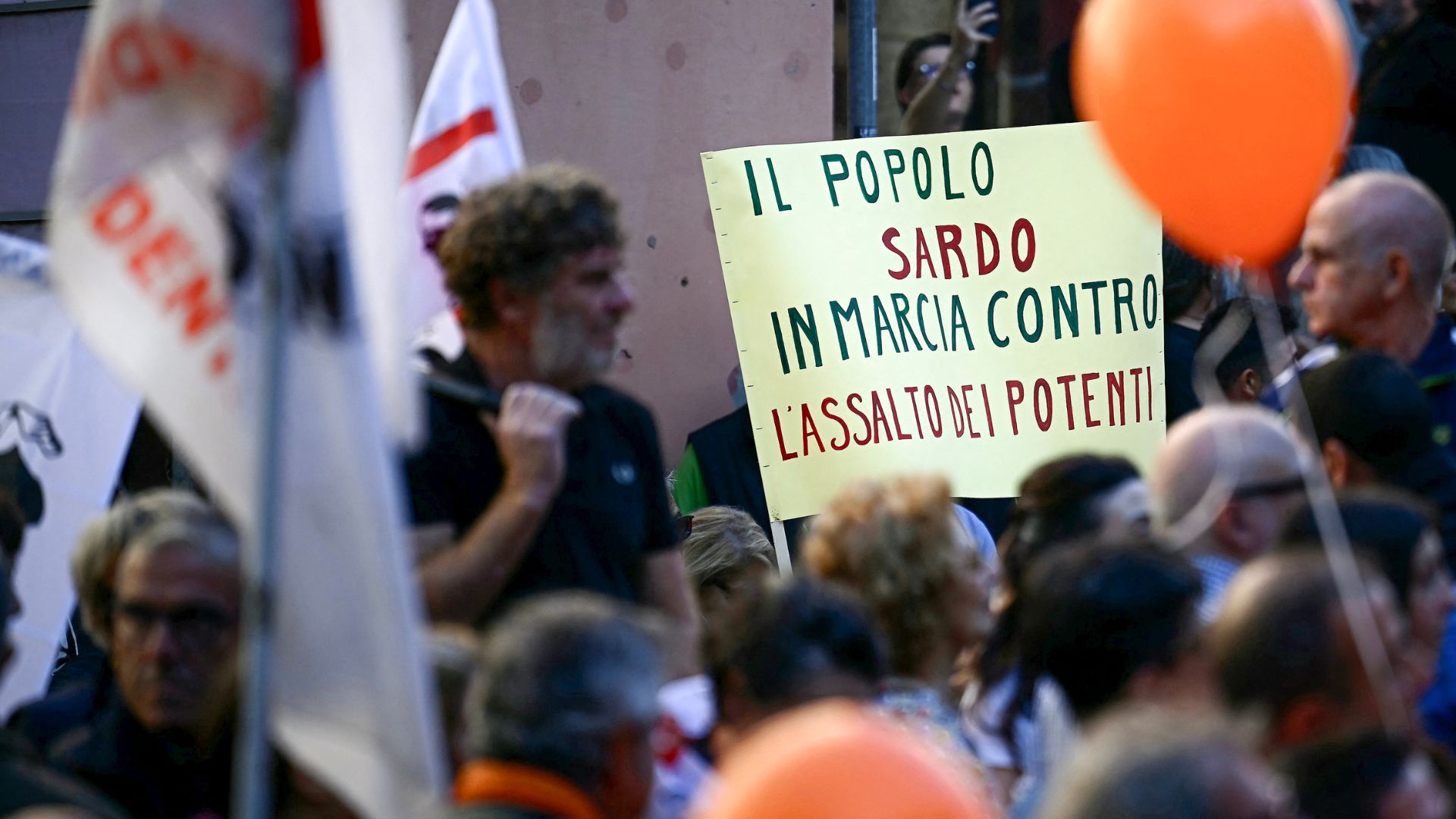 Demonstrators hold a placard reading 