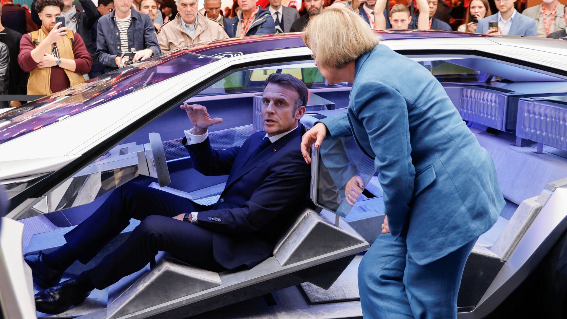 French President Emmanuel Macron sits in a Peugeot Inception concept car. /Ludovic Marin/Pool via Reuters