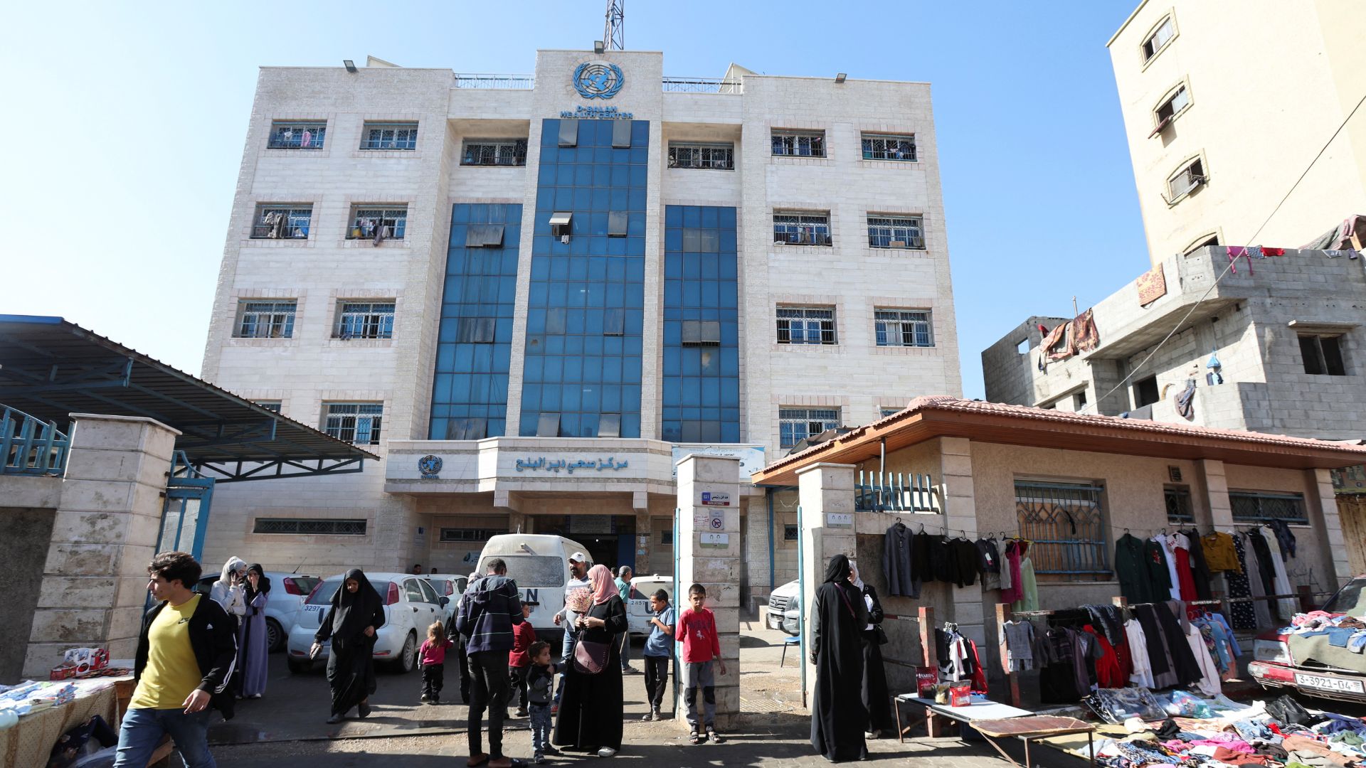 Palestinians walk outside a health center run by UNRWA in Deir Al-Balah, in the central Gaza Strip on Tuesday. /Ramadan Abed/Reuters