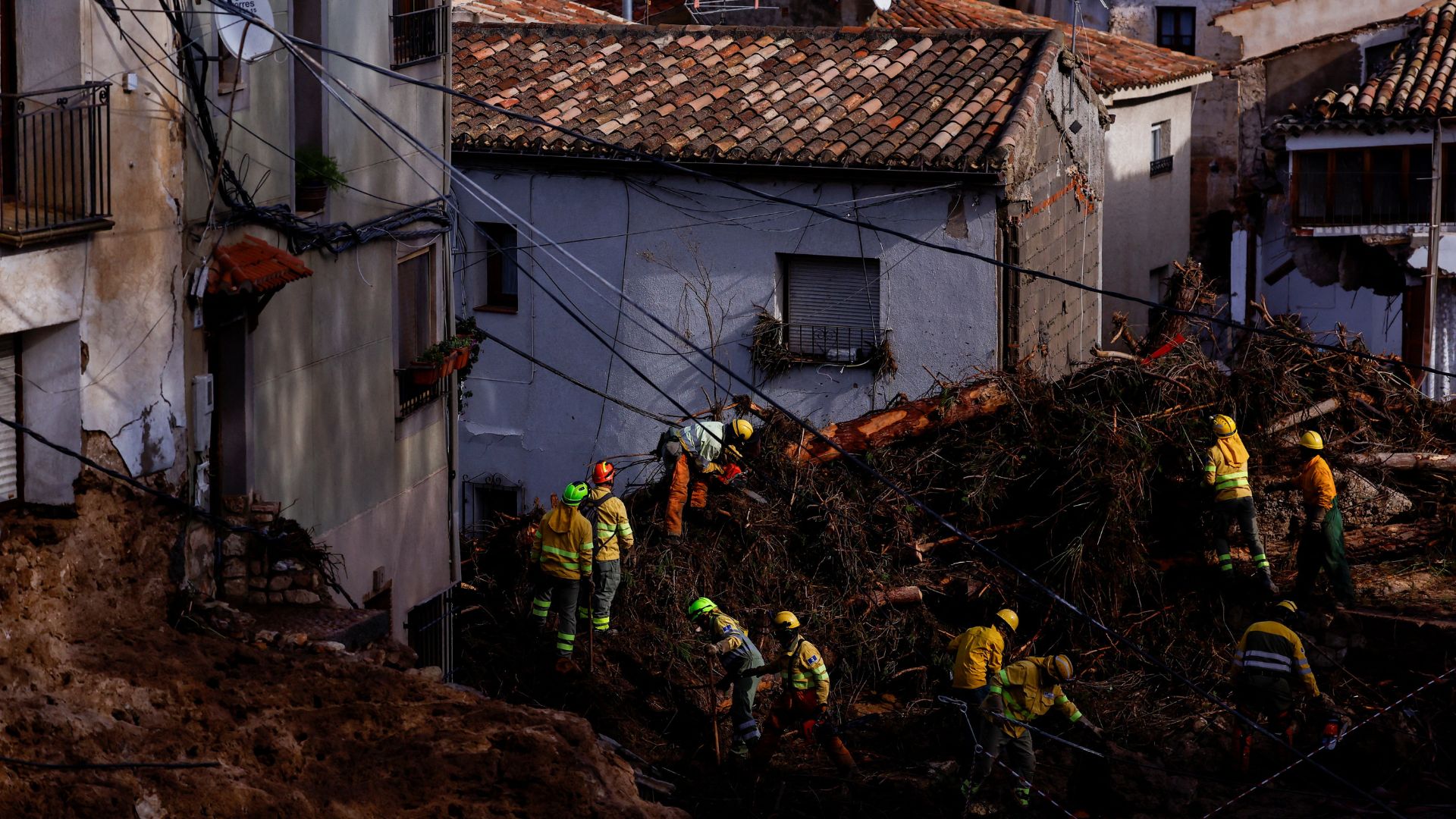 Firefighters work to clear debris in Letur after heavy rains caused flooding. /Susana Vera/Reuters