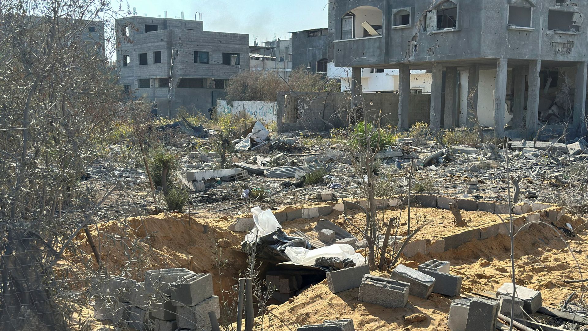 A mass grave in a yard is prepared for the burial of Palestinians killed in Israeli strikes, amid the Israel-Hamas conflict, in Beit Lahiya. /Reuters