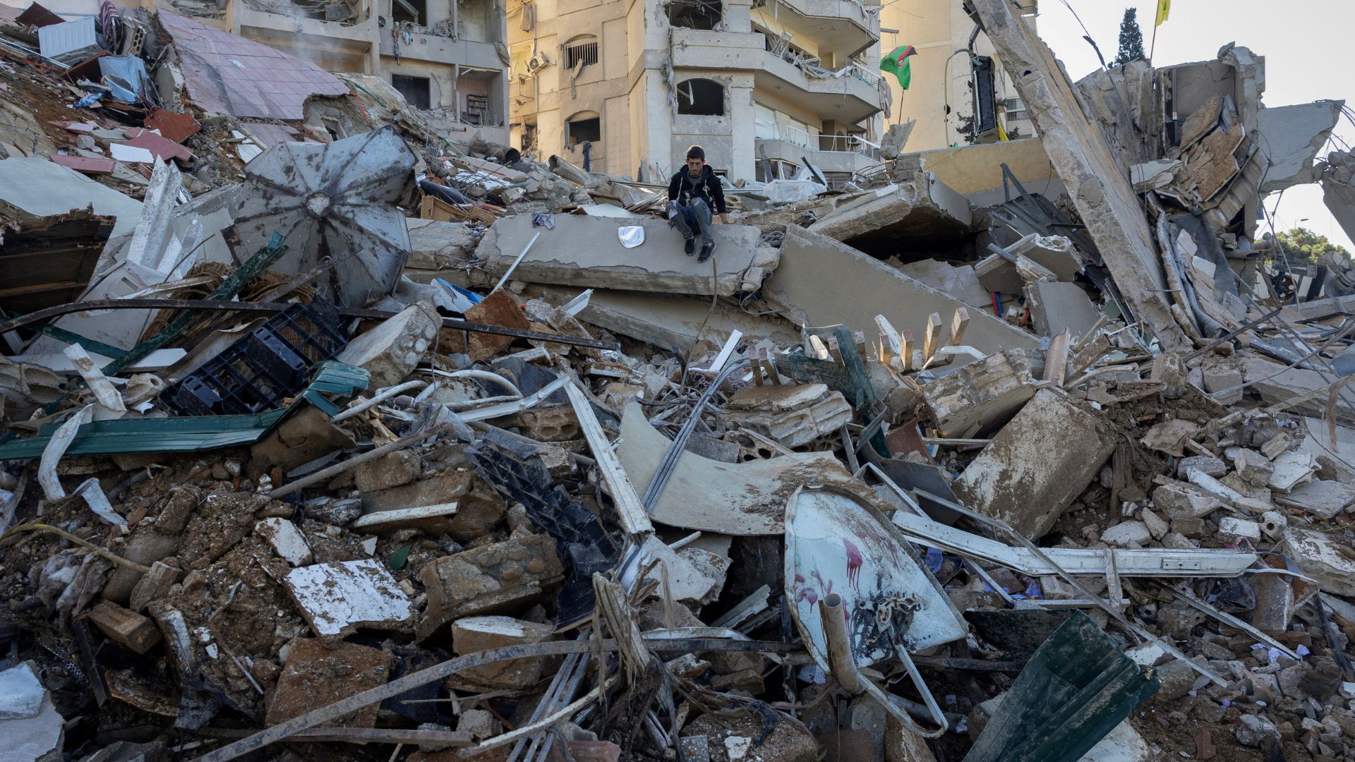 A man sits among the rubble of a damaged apartment building in the aftermath of an Israeli strike, amid the ongoing hostilities between Hezbollah and Israeli forces, in Tayouneh, Beirut. /Reuters