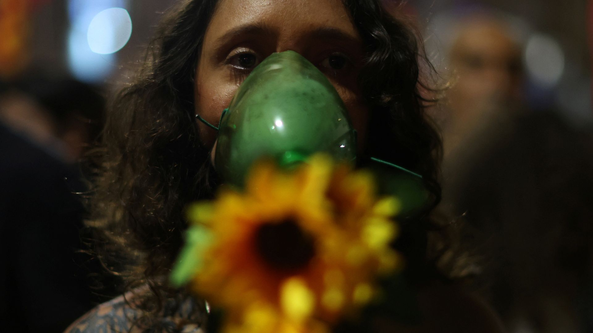 A woman wearing a mask made with a plastic bottle and flowers, attends the global Fridays for Future climate demonstration in Rio de Janeiro, on September 20. /Pilar Olivares/Reuters
