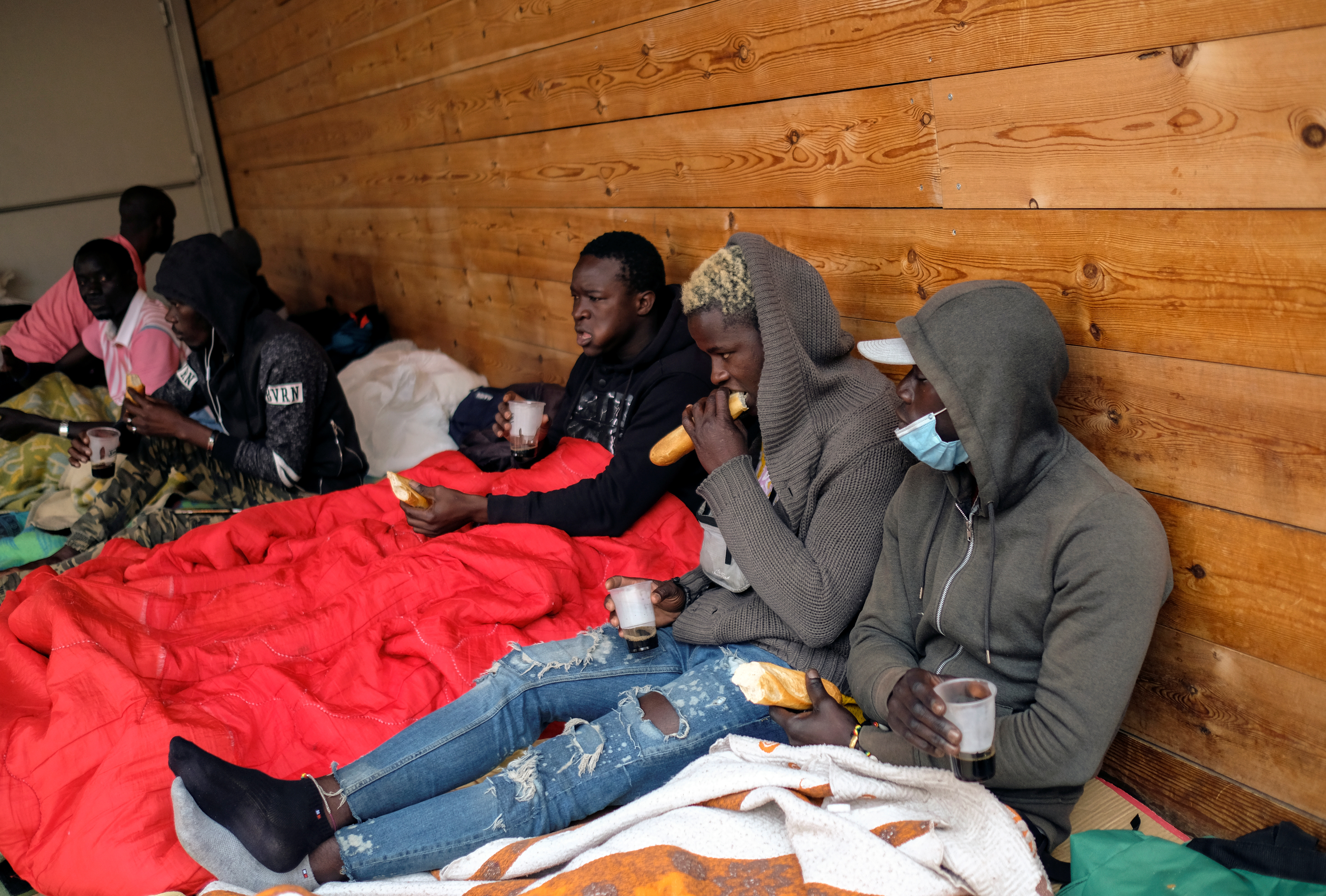 African immigrants eat bread and drink coffee as they live on the streets while waiting for available fruit picking jobs, in Lleida. /Nacho Doce/Reuters/Archive