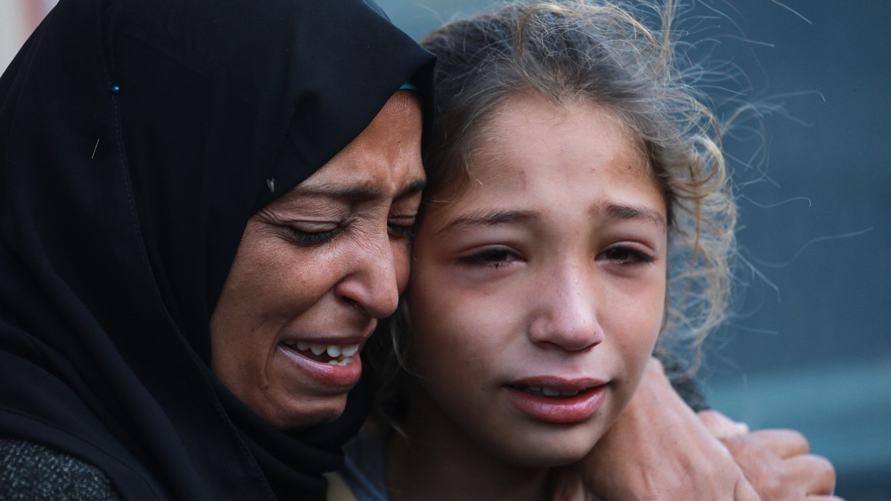 Palestinians at the al-Aqsa Martyrs Hospital in Deir el-Balah in Gaza where victims of an Israeli strike at UN-run school in the Nusseirat refugee camp were brought. /Bashar Taleb/AFP