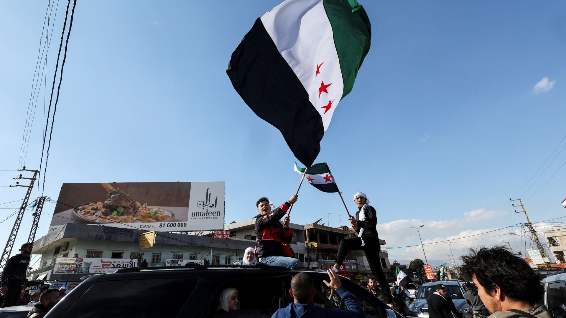 People wave Syrian opposition flags at the Masnaa border crossing with Lebanon. /Amr Abdallah Dalsh/Reuters
