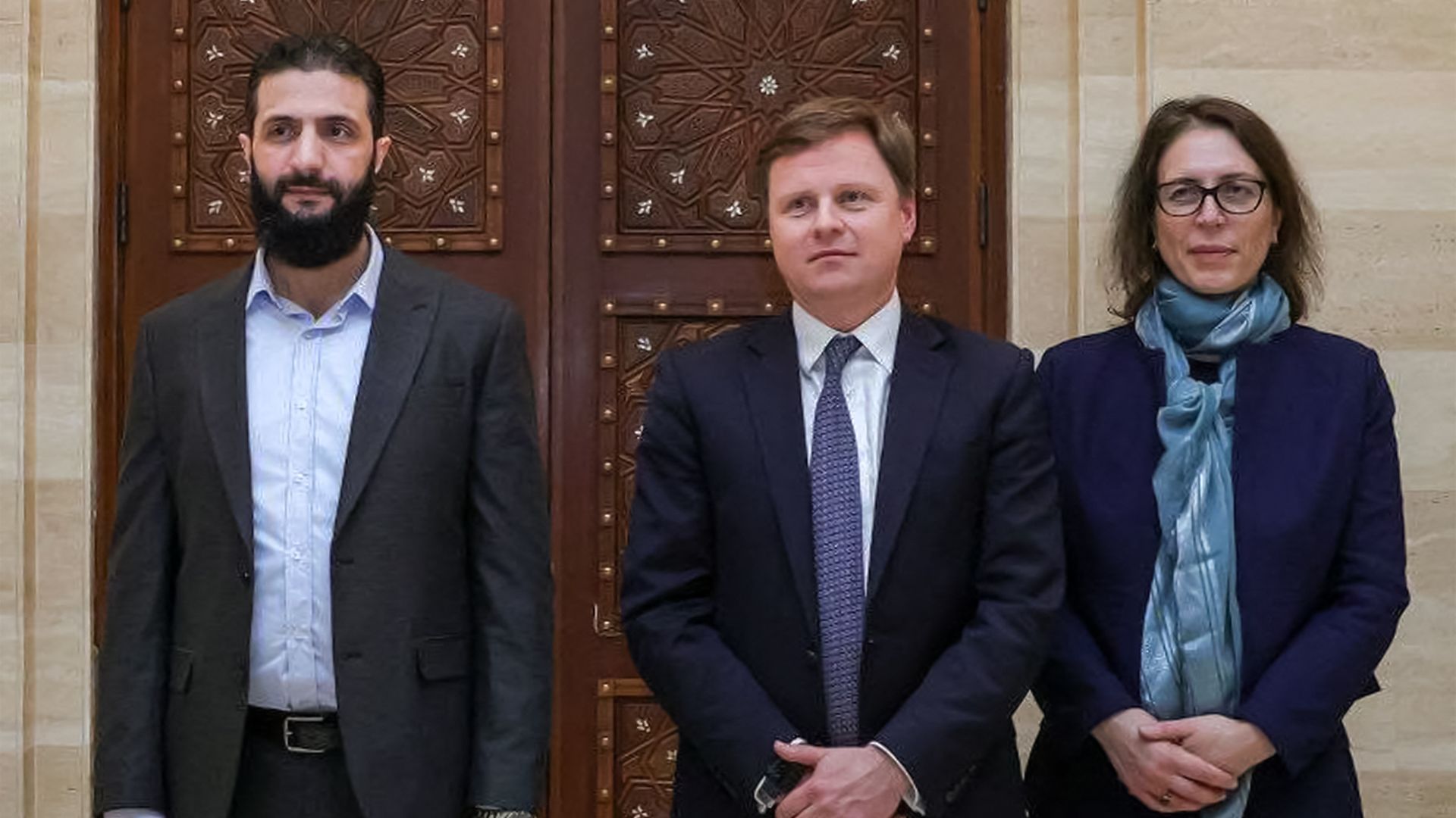 HTS head Ahmed al-Sharaa (formerly known as Abu Mohammed al-Jolani) pictured (L) with Stephen Hickey (C), director of the Middle East and North Africa department at the UK's Foreign Ministry in Damascus. /SANA/AFP
