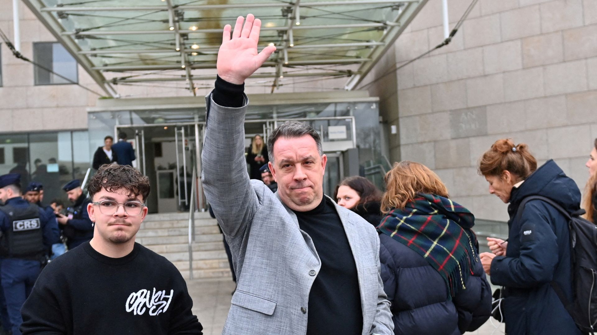 David, one of the two sons of Frenchwoman Gisele Pelicot, waves to supporters of her mother outside the courthouse after the verdict. /Alexandre Dimou/Reuters
