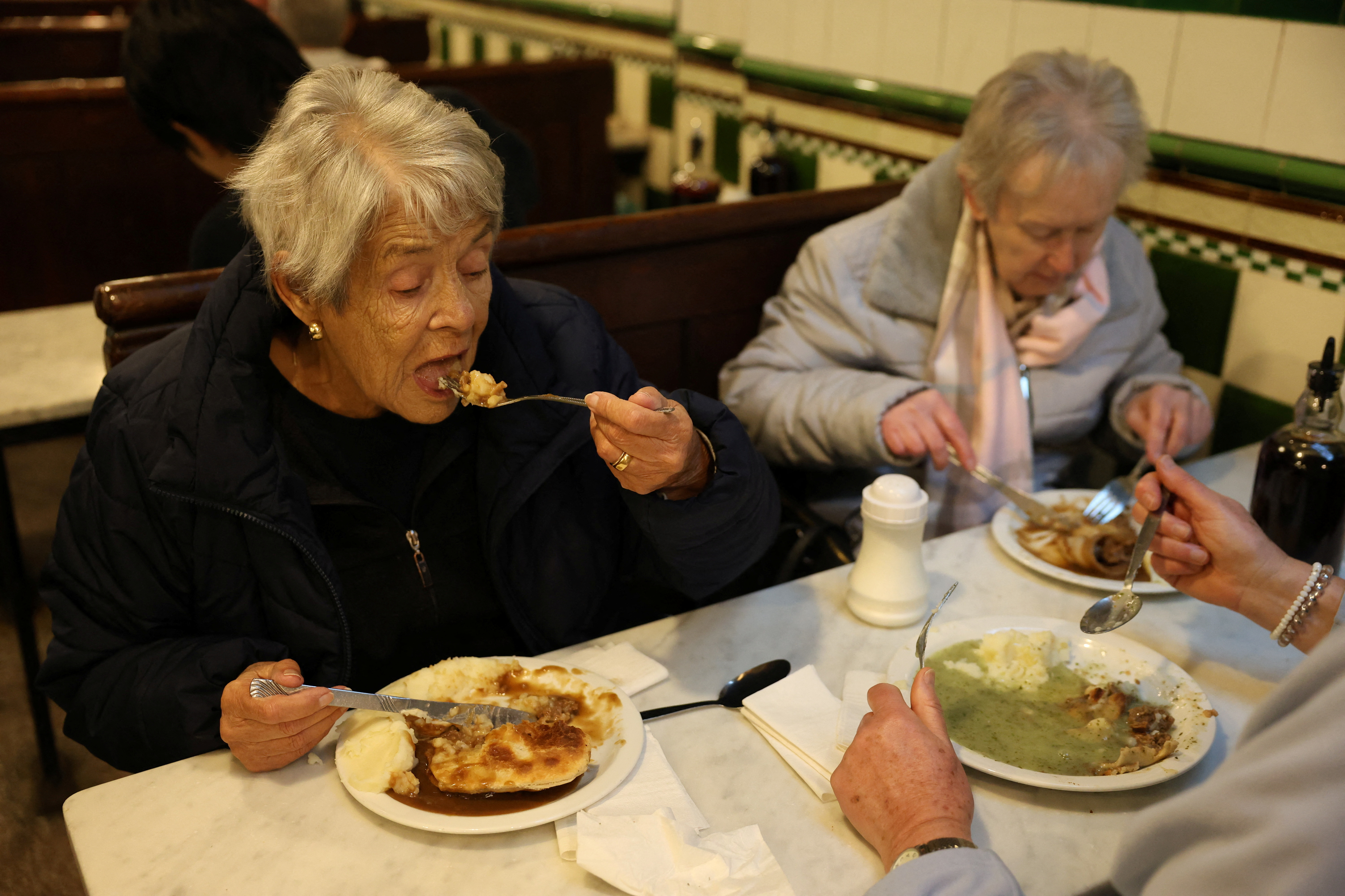 Fay Prestidge and Maureen Komjati, eat pie and mash at M. Manze. /Mina Kim/Reuters
