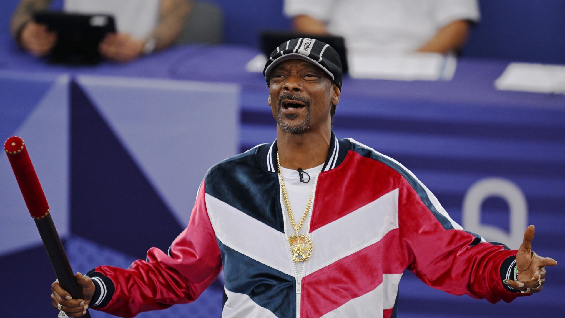 Snoop Dogg holds a baton to signal the official start of the B-Girls Pre-Qualifier Battle competition in breakdancing. /Angelika Warmuth/Reuters