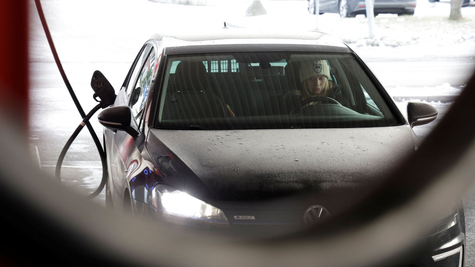 A woman charges her car at a station that offers car charging points and fuel, in Sandvika near Oslo. /Leonhard Foeger/Reuters
