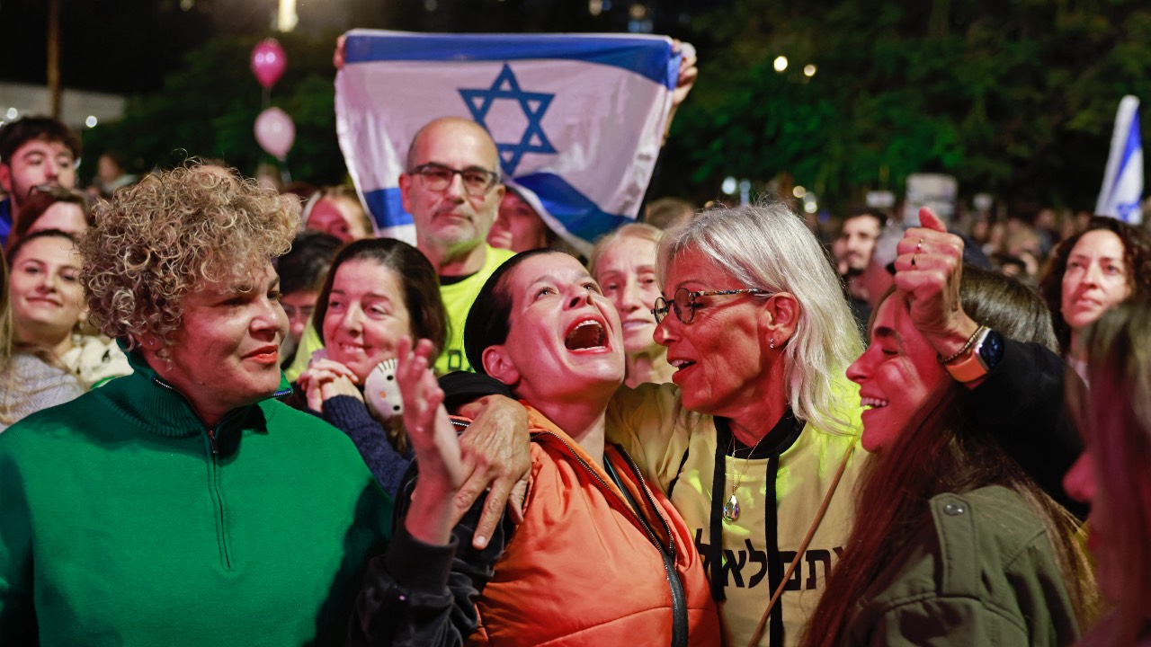 The crowds in Tel Aviv's 'Hostage Square' cheered at the news that the first three hostages freed under the Gaza ceasefire deal had returned to Israel. /Menahem Kahana/AFP