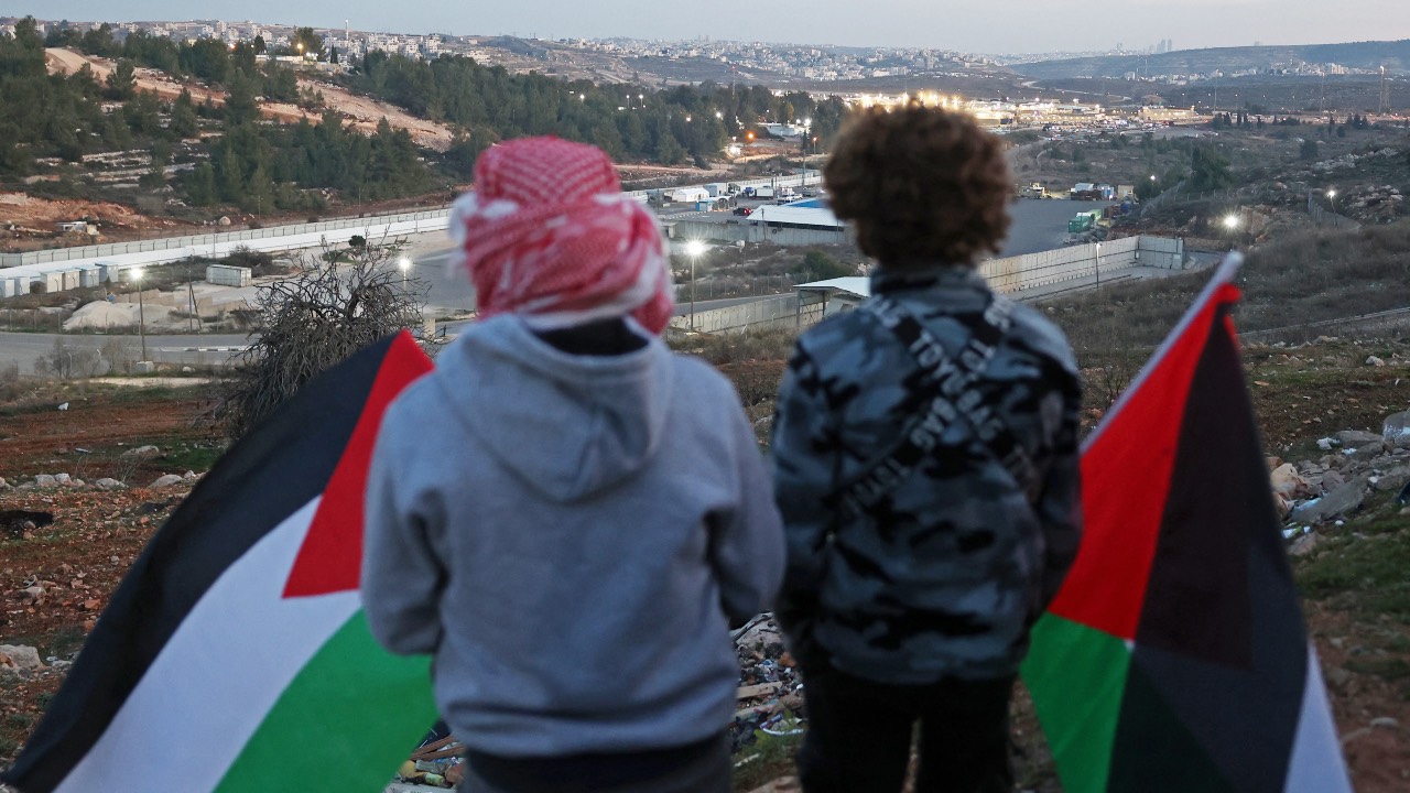 Family members and relatives of Palestinian prisoners, wait for their release against the backdrop of Ofer Prison, in the west of Ramallah. /Zain Jaafar/AFP