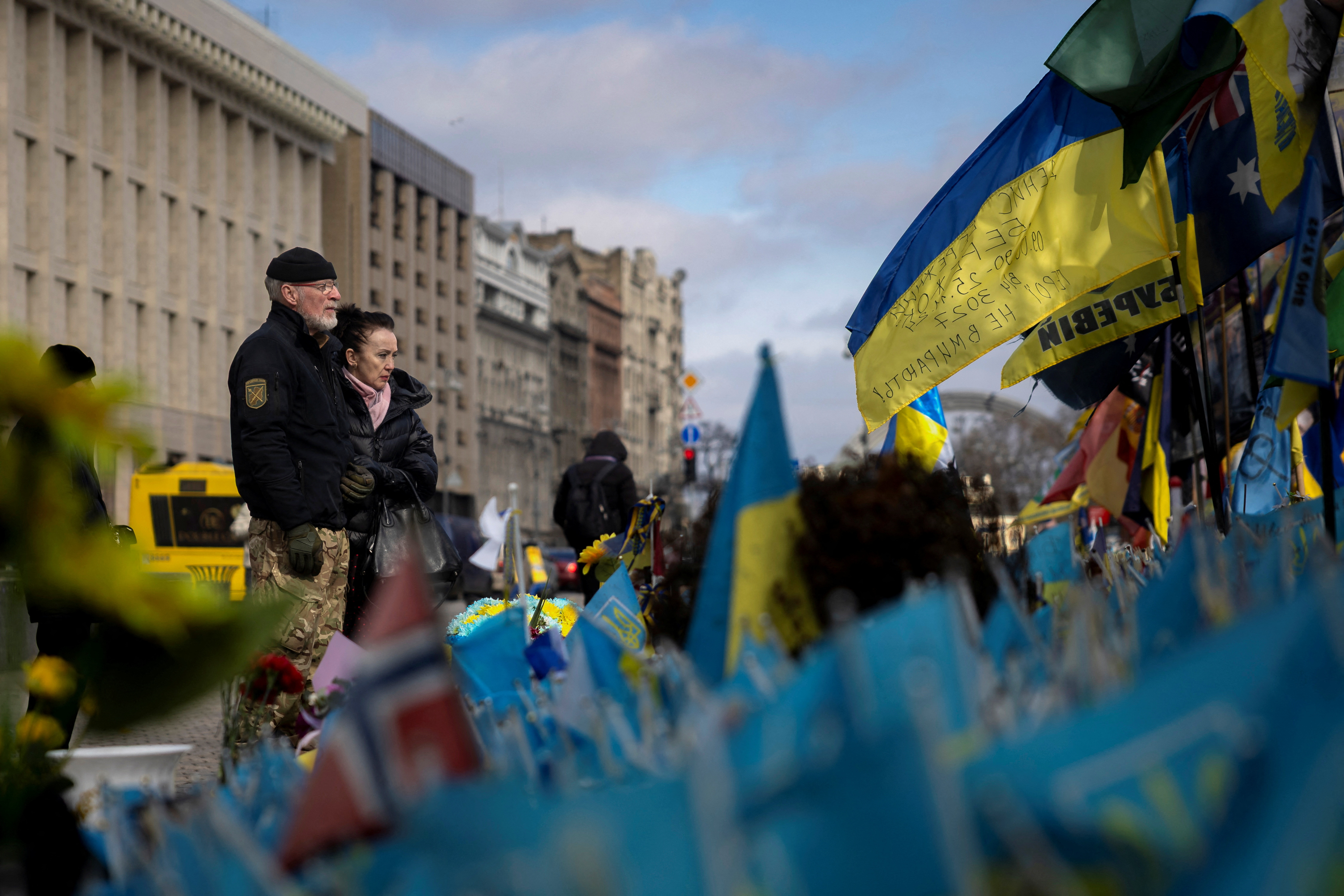People look at a memorial for fallen soldiers fighting for Ukraine, at Independence Square, amid Russia's attack on Ukraine, in Kyiv on March 4. /Thomas Peter/Reuters