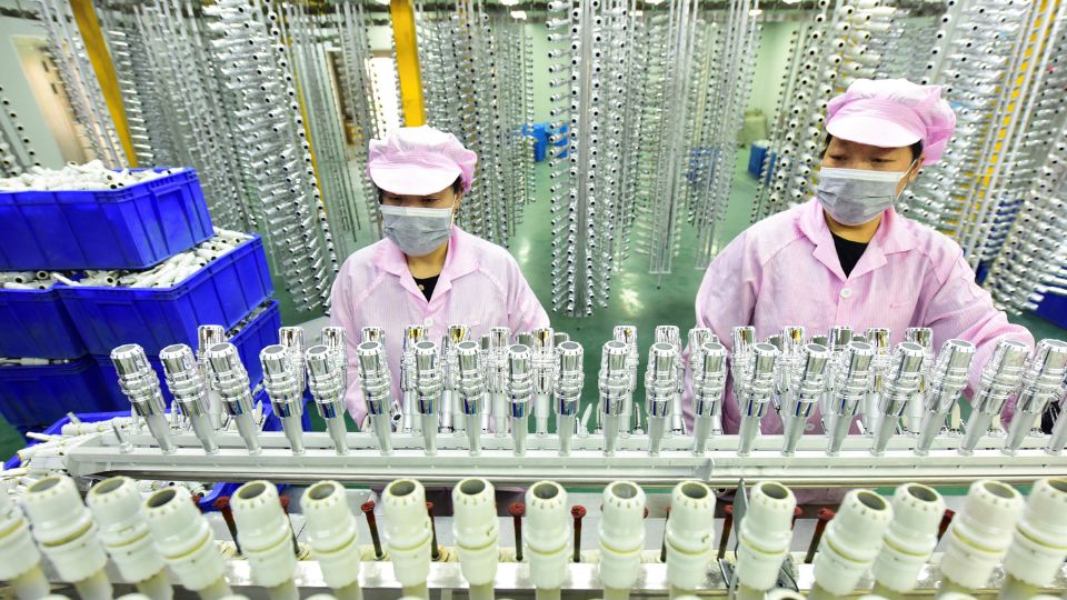 Workers on a production line manufacturing bottle caps for export at a factory of a packaging company in Donghai county of Lianyungang, Jiangsu province, China. China Daily via Reuters