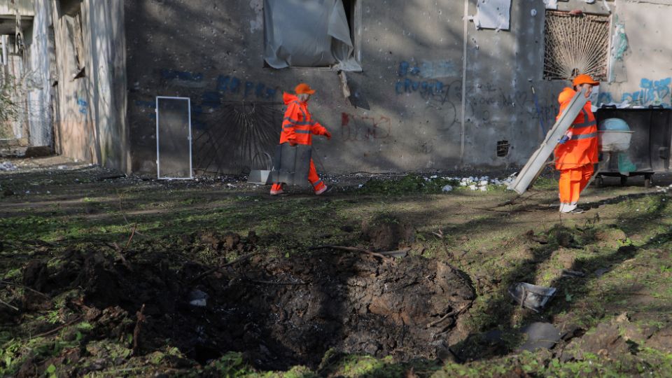 Municipal workers clean debris near a damaged residential building following a Russian drones strike in Odesa on April 22. /Oleksandr Gimanov/AFP
