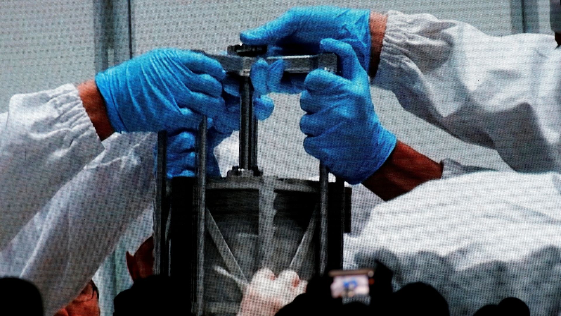 Researchers hold an equipment carrying a Chang'e-5 lunar sample. /Tingshu Wang/Reuters