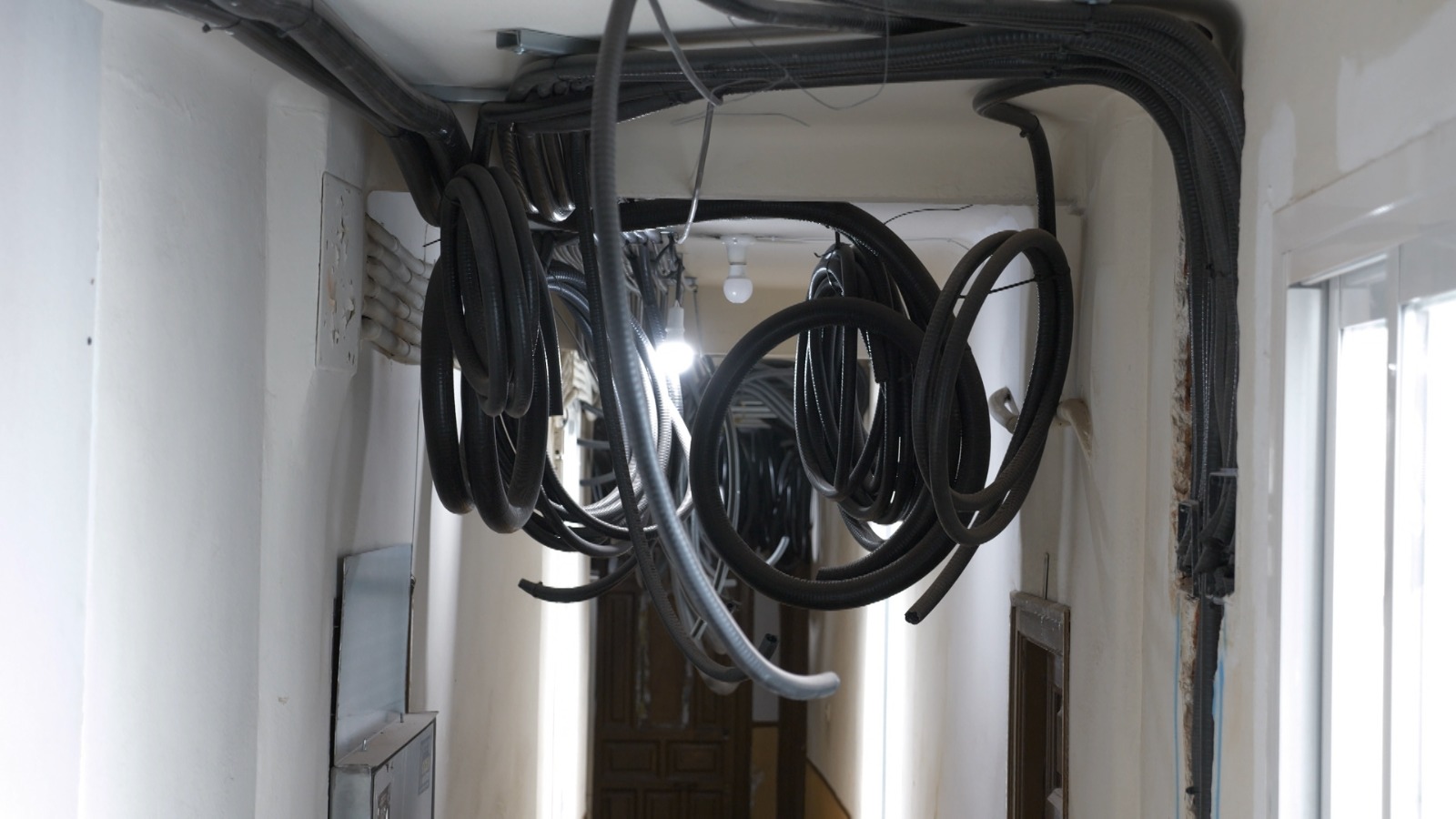Pipes and tubes hang from the ceiling in the building. /CGTN