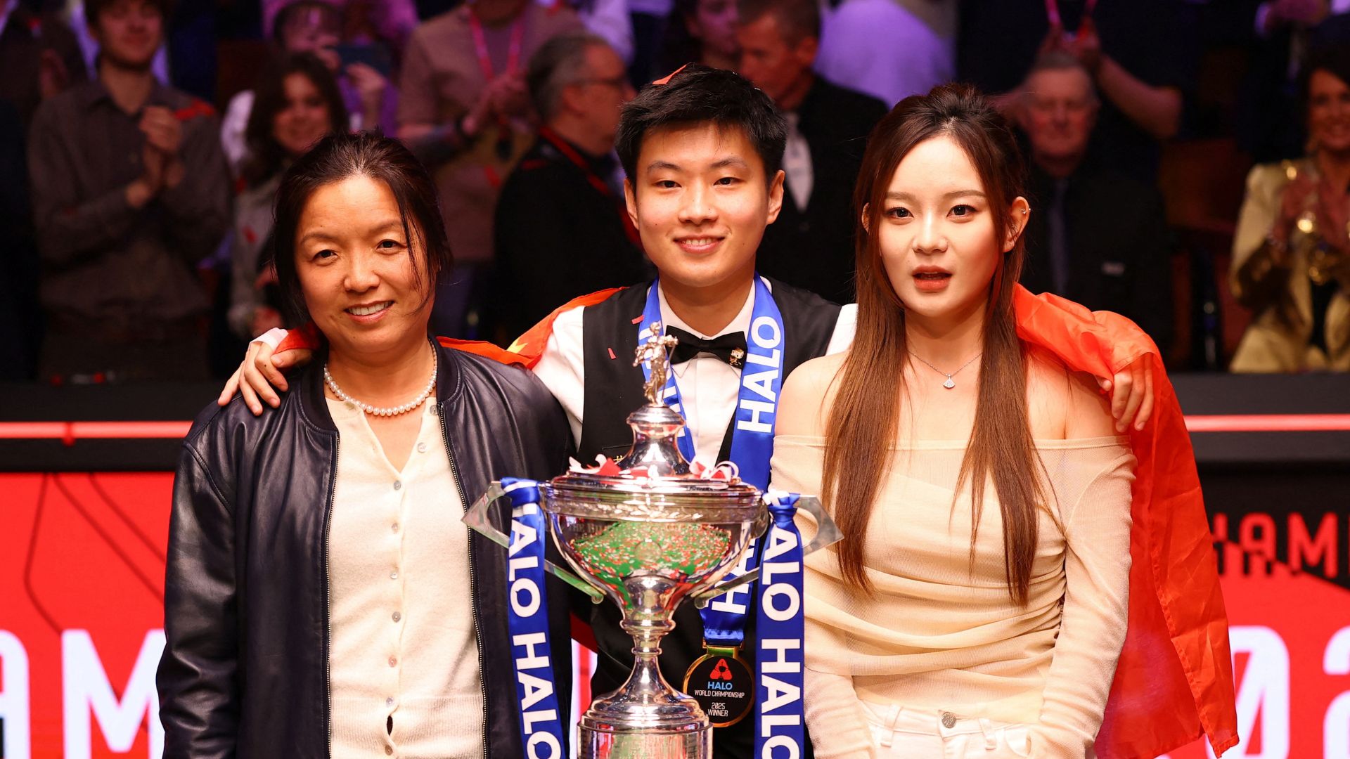 Zhao Xintong poses with the trophy, his manager Victoria Shi and his partner Yi Yi. /Andrew Boyers/Action Images via Reuters
