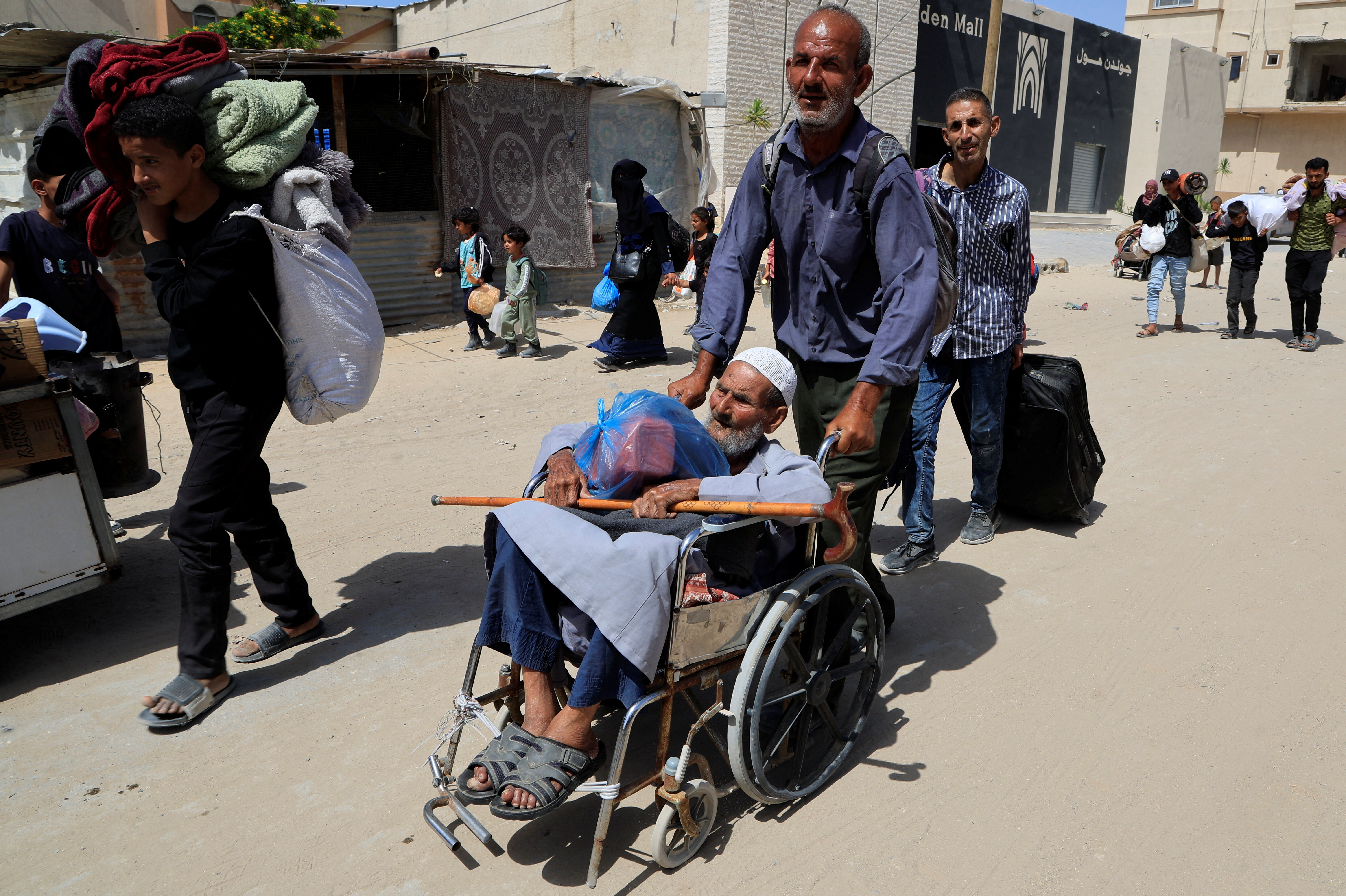 Palestinians make their way with belongings as they flee their homes after the Israeli military issued orders for evacuation from eastern Khan Younis. /Hatem Khaled/Reuters
