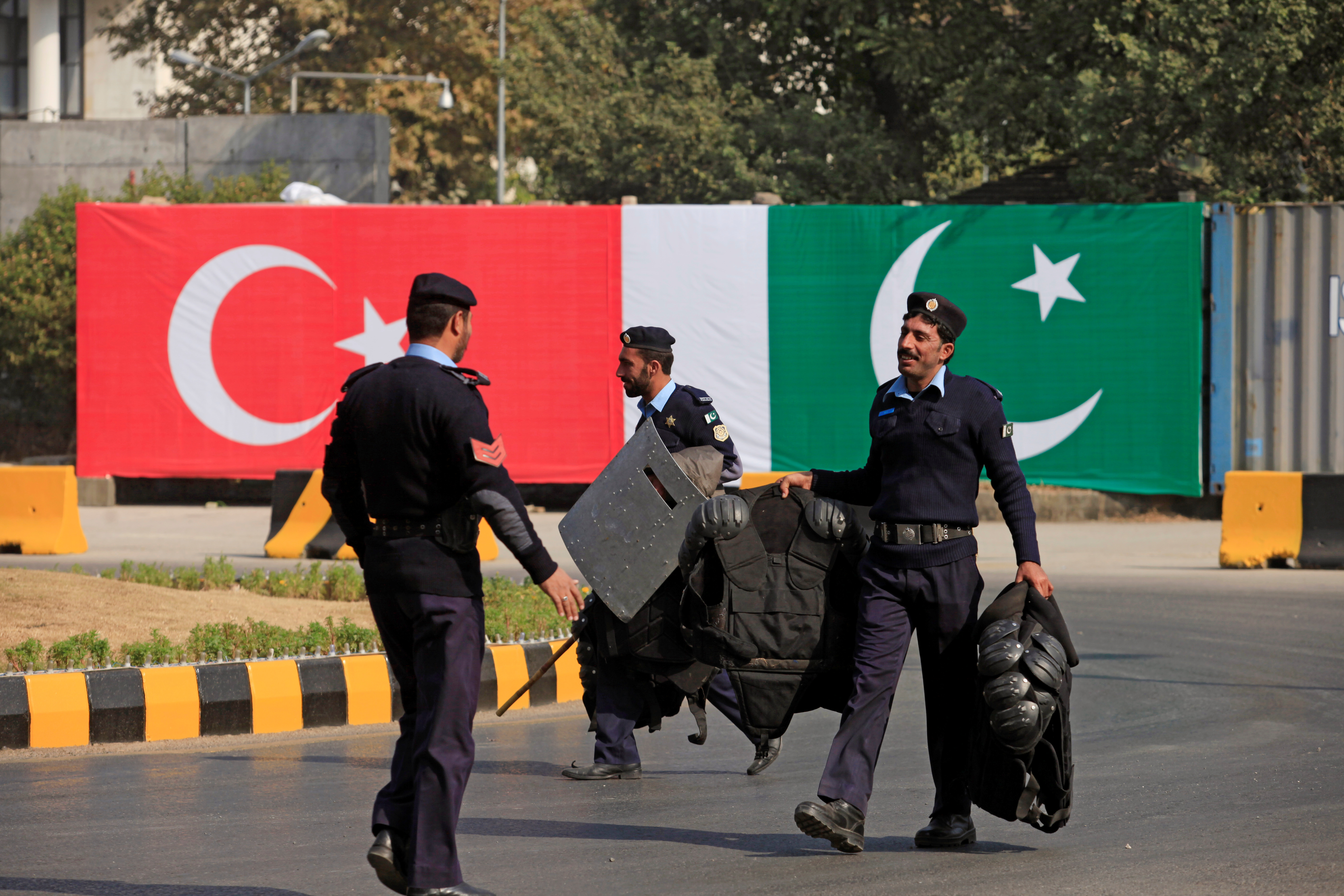 Policemen walk near the national flags of Pakistan and Türkiye displayed along a road ahead of a visit of Turkish President Tayyip Erdogan in Islamabad in 2016. /Faisal Mahmood/Reuters