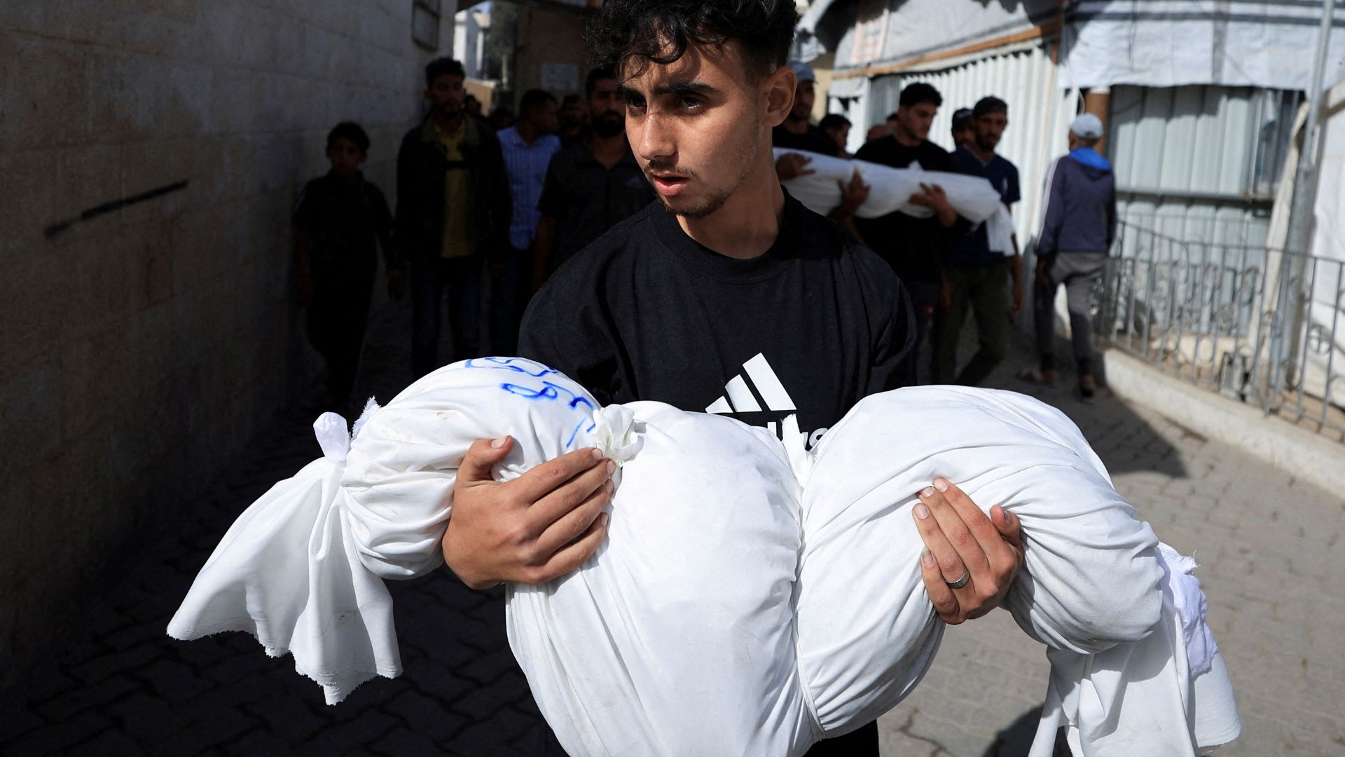 A mourner holds a body during the funeral of Palestinians killed in Israeli strikes on Gaza City, Monday. /Dawoud Abu Alkas/Reuters