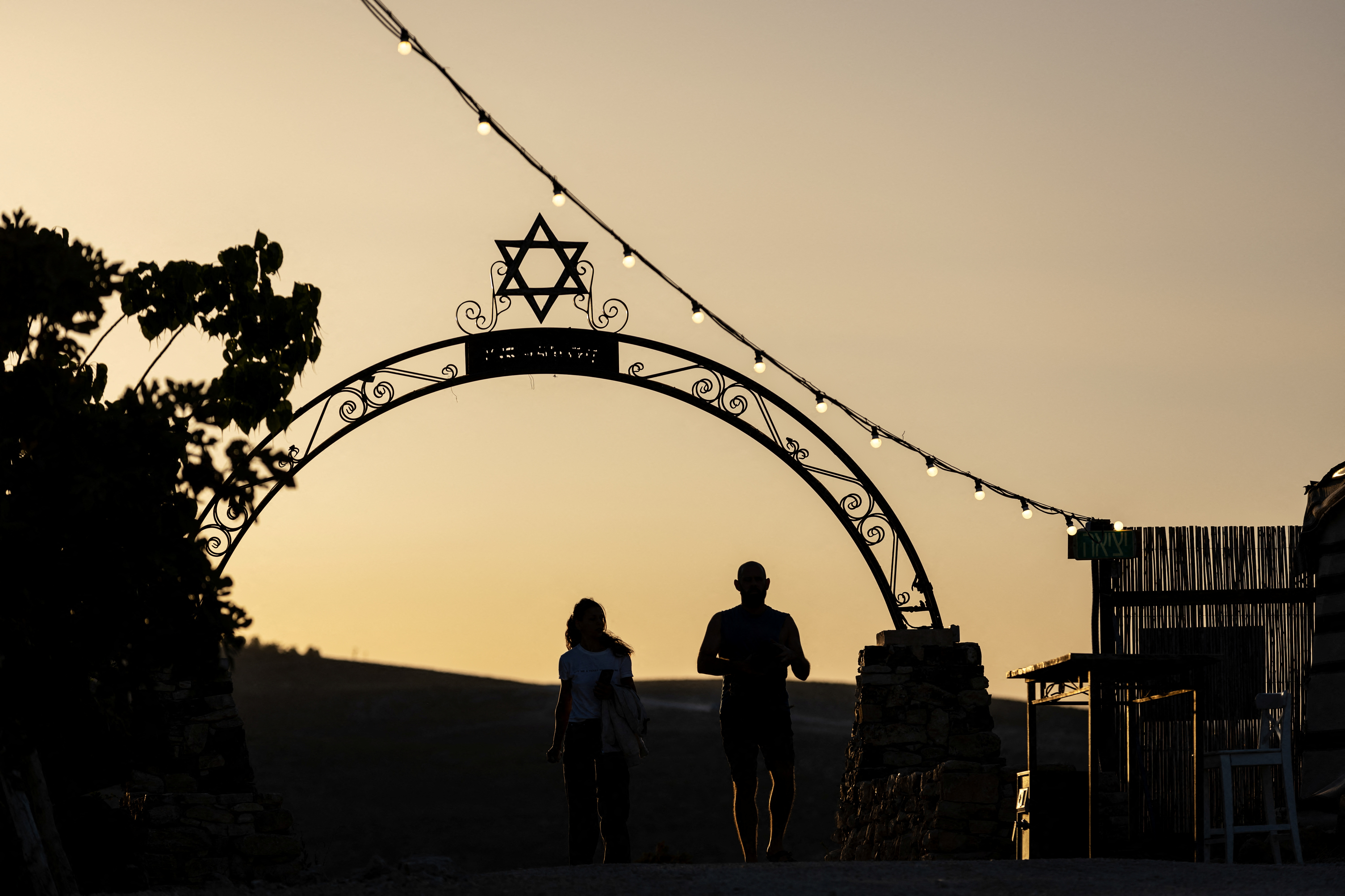 Visitors jog by the entrance to Kedar Sheep farm near the Jewish settlement of Kedar in the Israeli-occupied West Bank. /Ronen Zvulun/Reuters