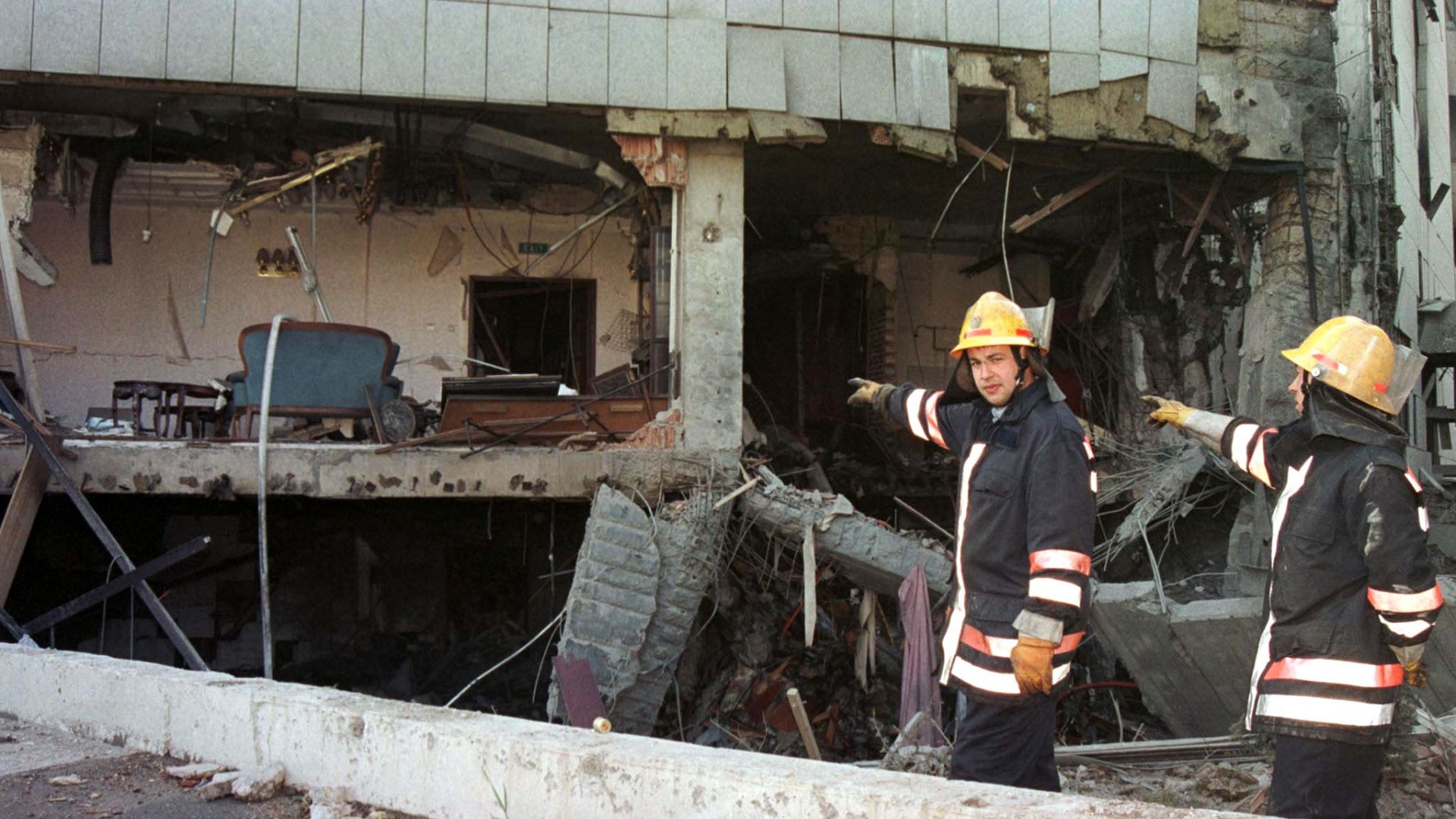 Firemen point at the heavily damaged Chinese embassy in Belgrade after it was hit by NATO missiles on May 7, 1999. /Archive/Reuters 
