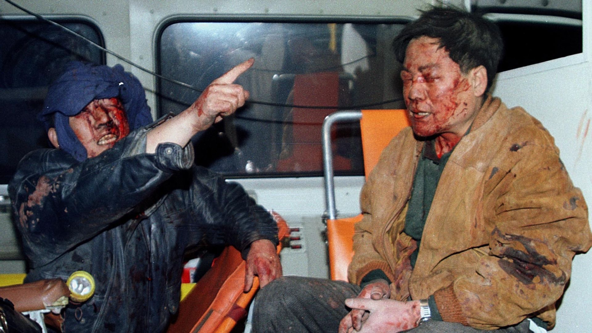 Two injured Chinese men sit in an ambulance outside the Chinese embassy after the NATO air strikes. /Archive/Reuters 

