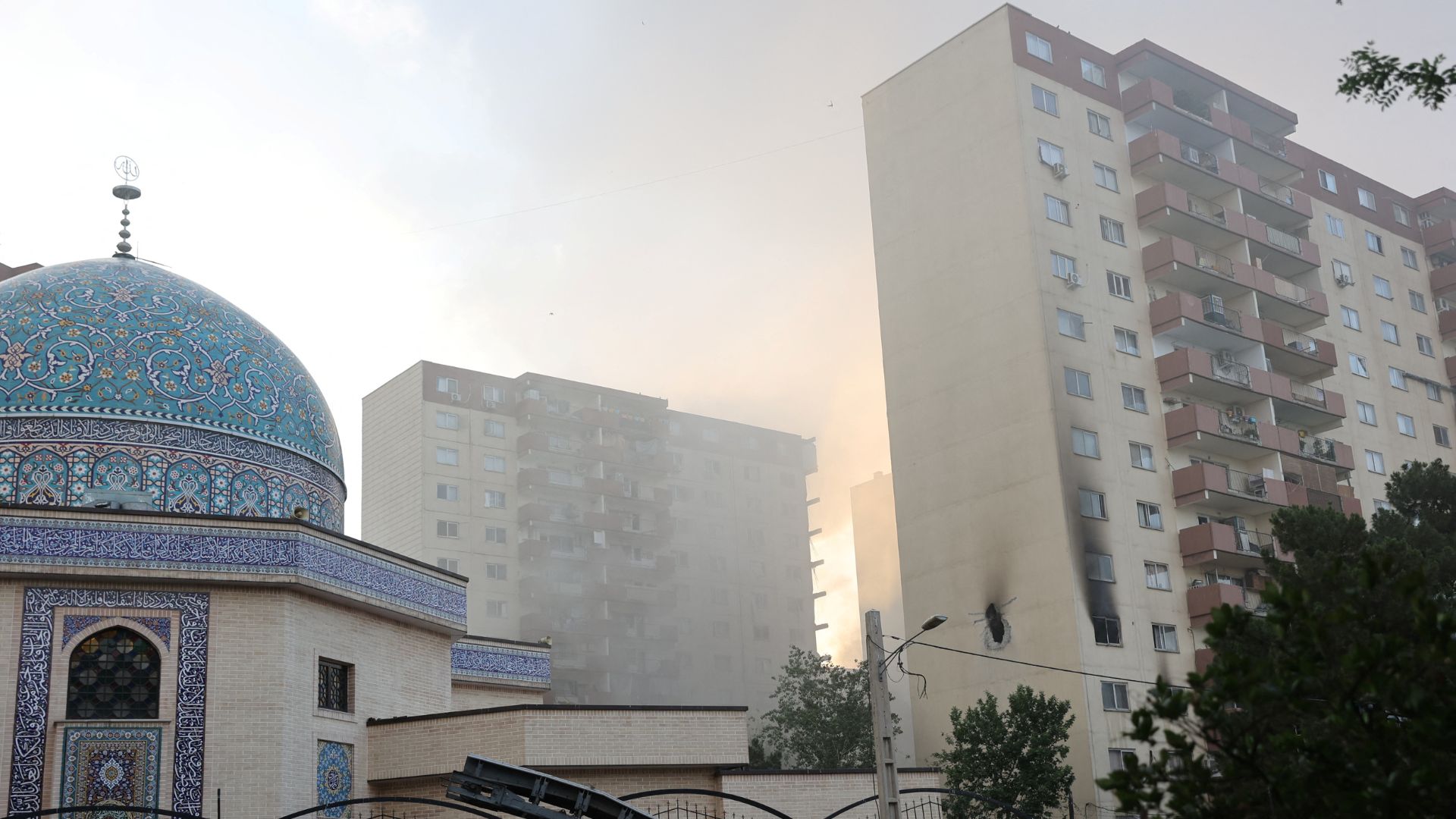 Smoke rises as a building stands damaged in the aftermath of Israeli strikes, in Tehran. /Majid Asgaripour/West Asia News Agency