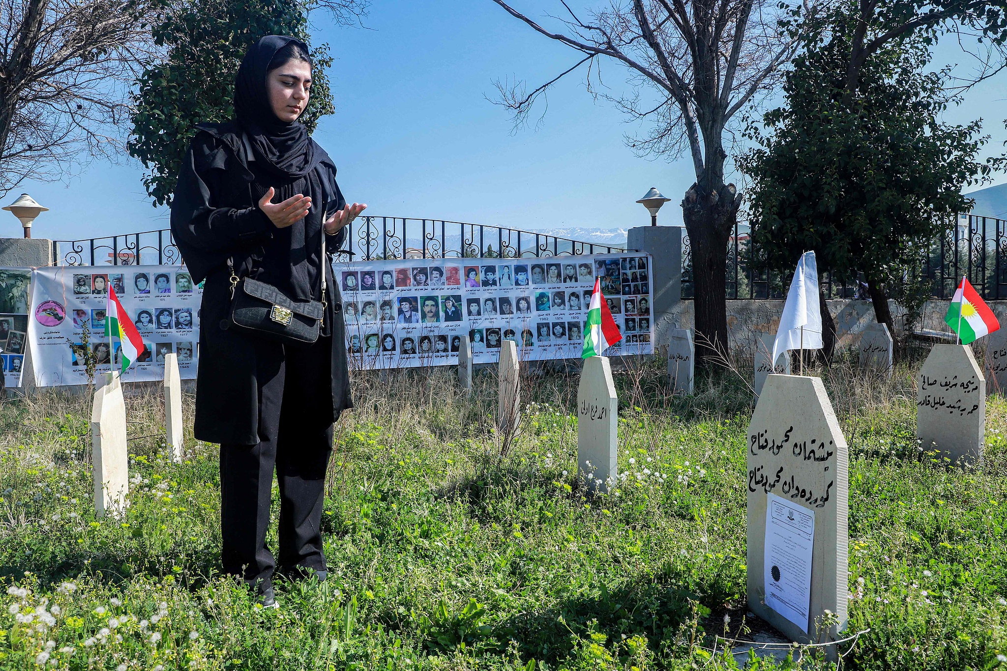 A woman prays by the grave of one of the victims of the 1988 Halabja chemical attack, during memorial commemorations of the 37th anniversary of the massacre which killed some 5,000 people. /Shwan Mohammed/CFP

