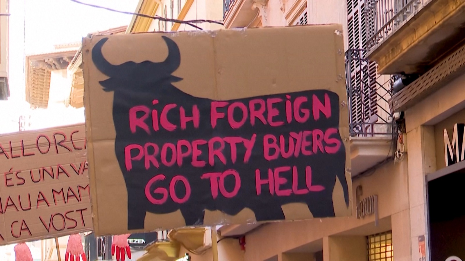 3/4. A Madrid protester holds a sign protesting against foreign property buyers. /CGTN