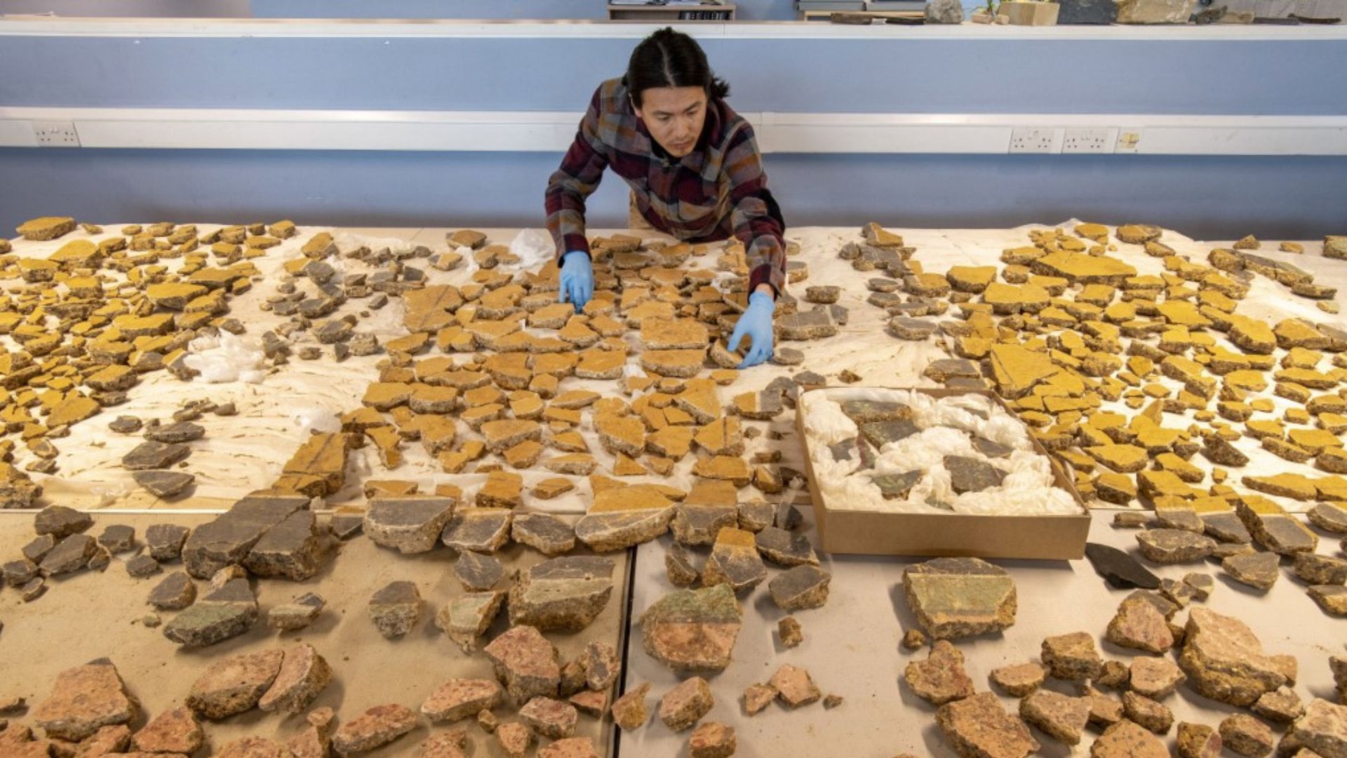 MOLA senior building material specialist Han Li laying out Roman plaster fragments from The Liberty development site in south London. /Handout/ Museum of London Archaeology (MOLA)
