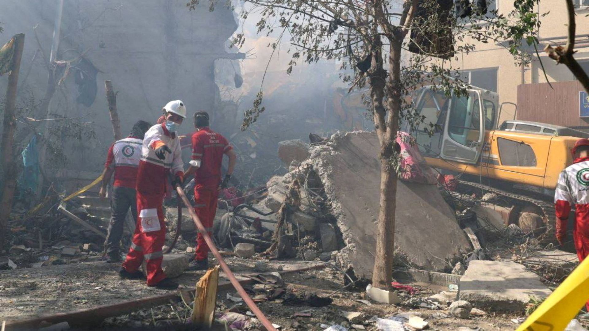 Rescuers at the site of a building damaged by Israeli strikes in Tehran. /Iranian Red Crescent Society/WANA handout via Reuters