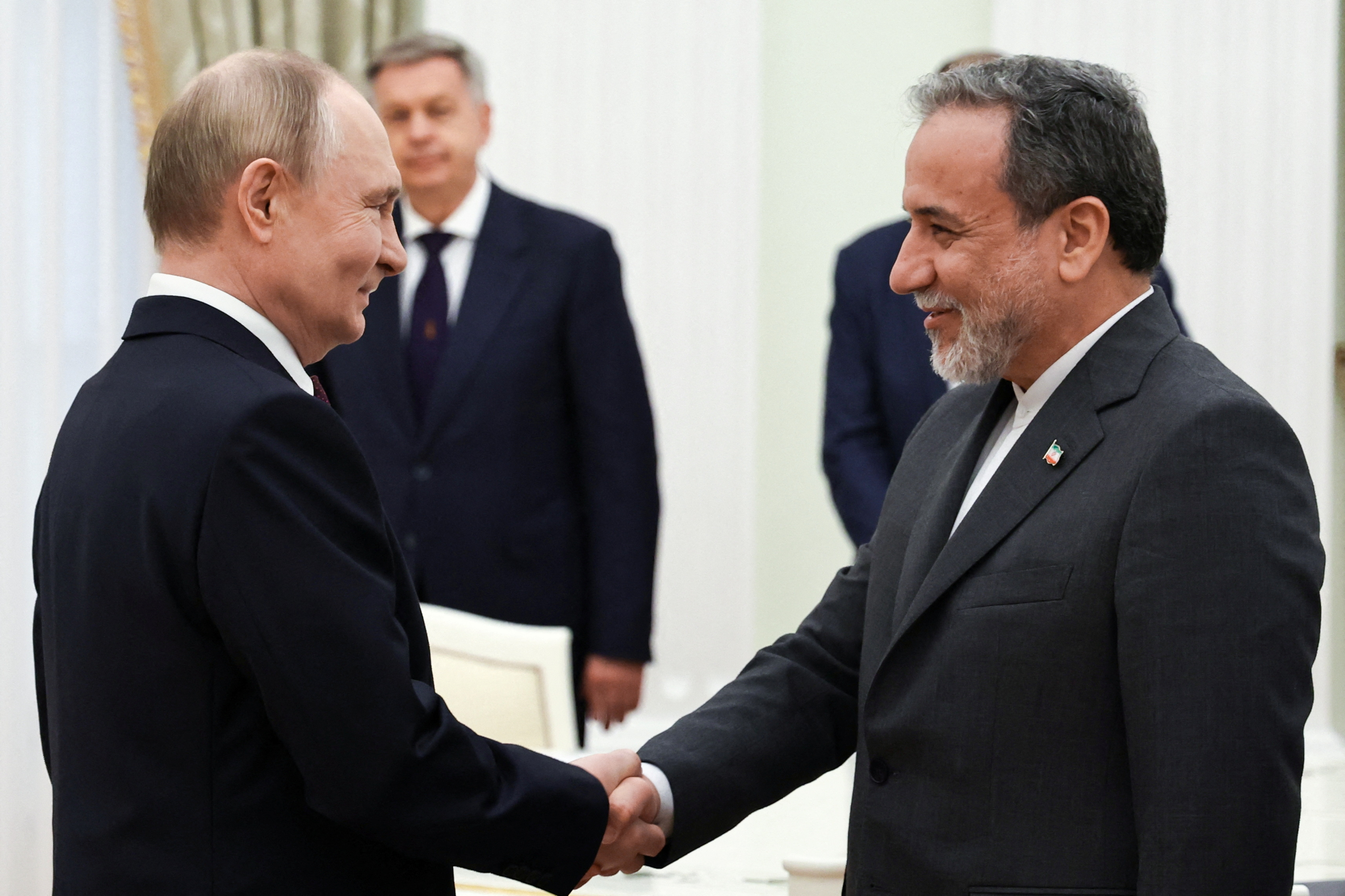 Russian President Vladimir Putin shakes hands with Iranian Foreign Minister Abbas Araghchi at the Kremlin on Monday. /Alexander Kazakov/Sputnik/Pool via Reuters