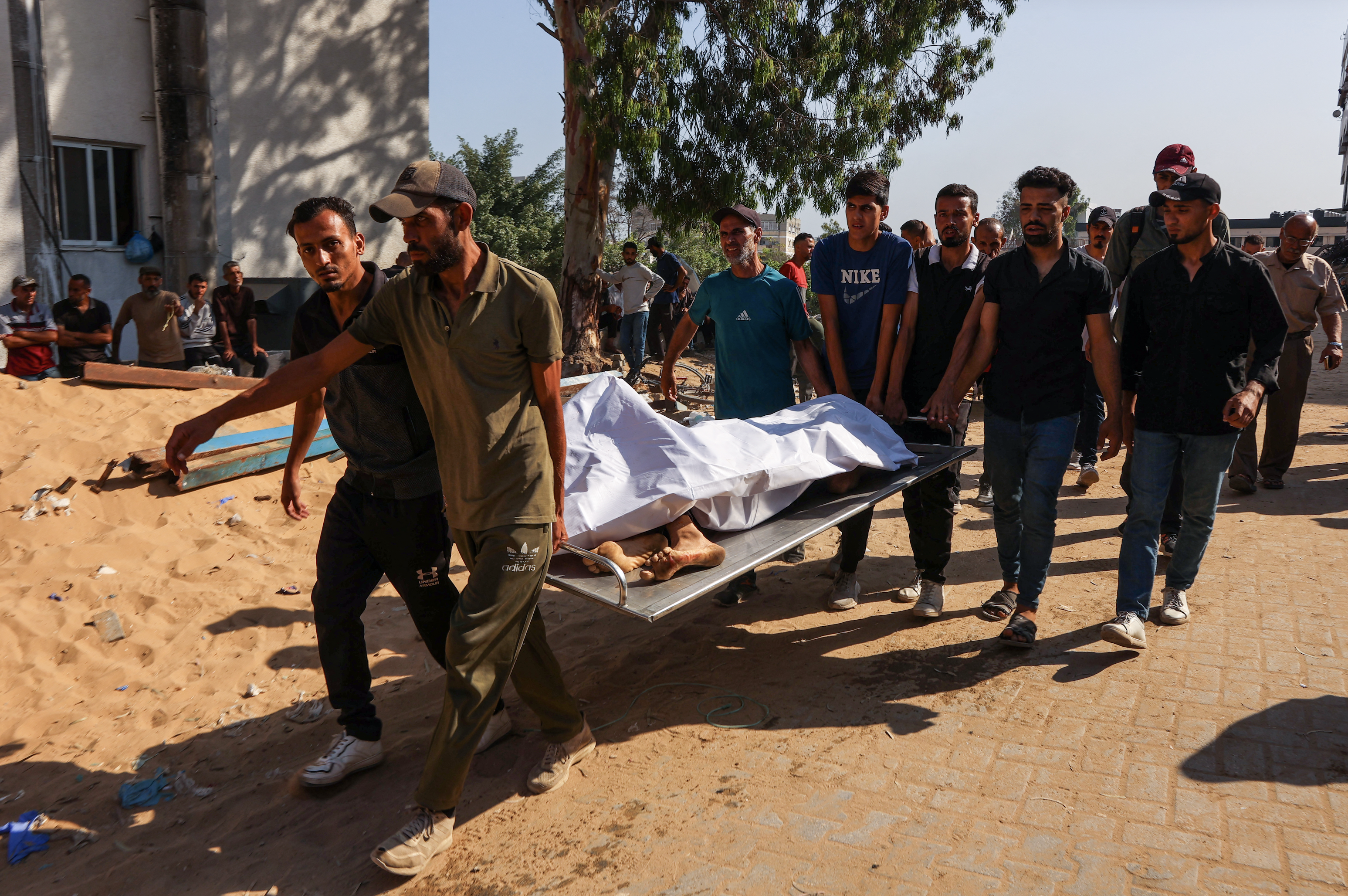 Palestinians carry the bodies of people killed during overnight Israeli strikes, at Al-Shifa hospital in the central Gaza Strip on June 28, 2025. /AFP