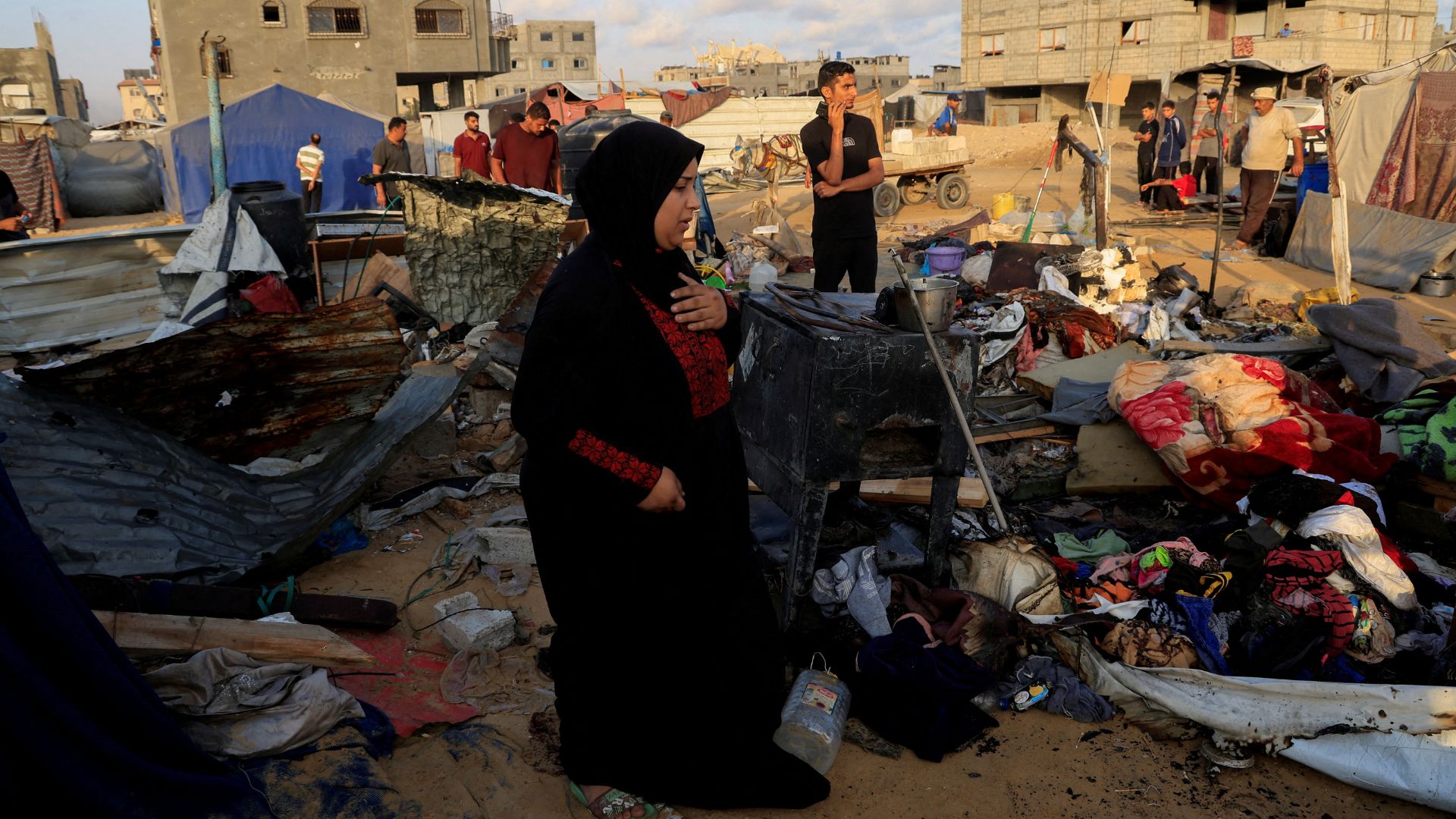 Palestinians inspect the damage at the site of an overnight Israeli air strike on a tent sheltering displaced people, in Khan Younis. /Hatem Khaled/Reuters
