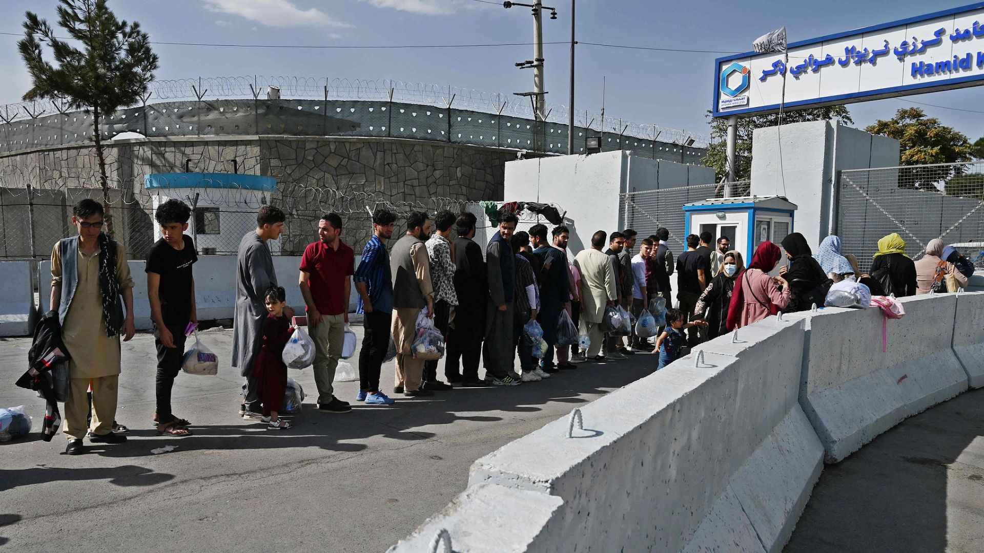 Afghans hoping to leave Afghanistan queue at the main entrance gate of Kabul airport following the Taliban military takeover. /Wakil Kohsar/CFP
