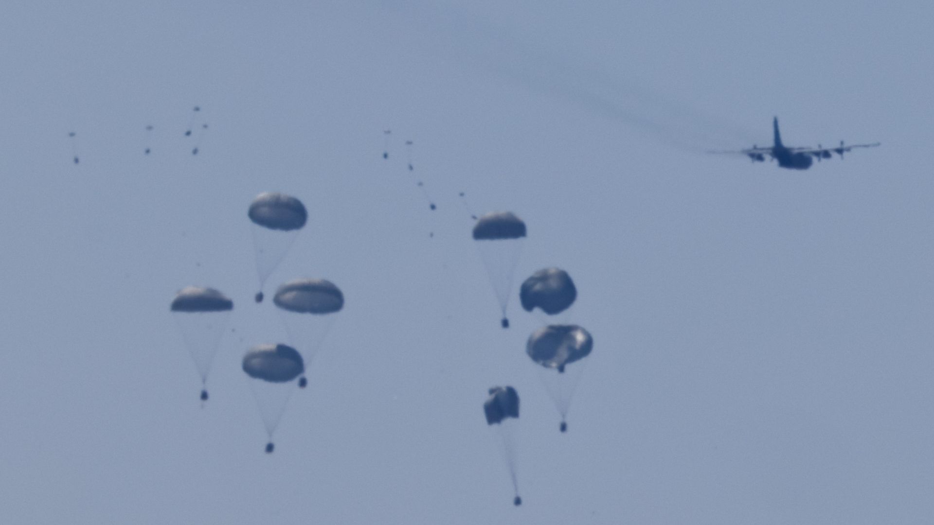 An aircraft drops humanitarian aid packages over the Gaza Strip, as seen from Israel. /Amir Cohen/Reuters
