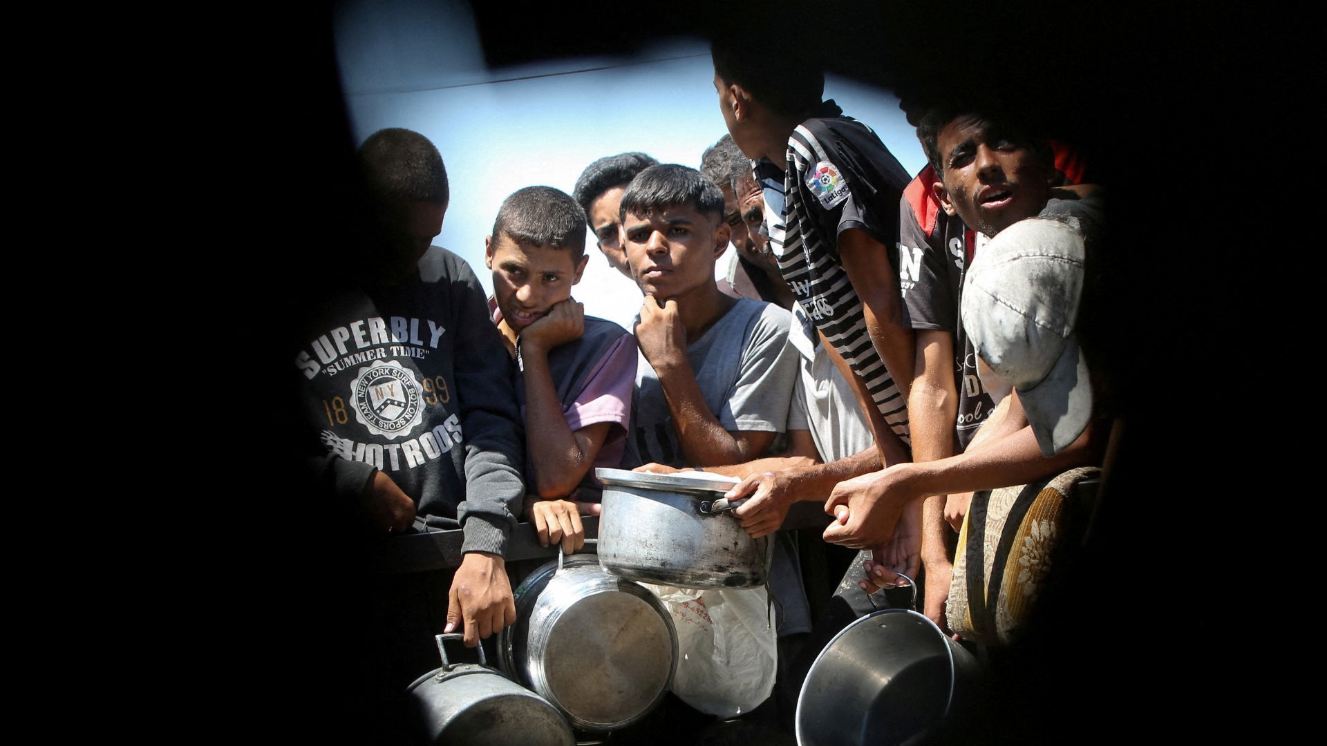Palestinians wait to receive food from a charity kitchen, amid a hunger crisis, in Khan Younis, southern Gaza Strip. /Hatem Khaled/Reuters