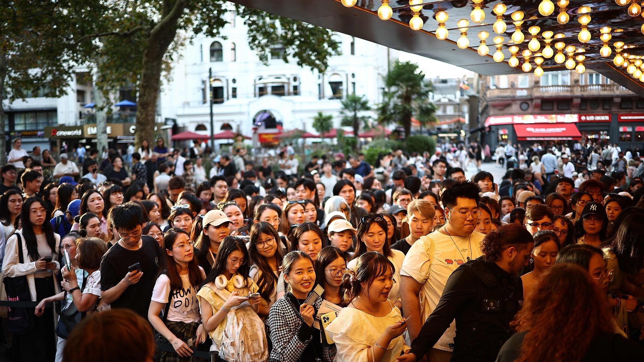 Cinemagoers queue outside to attend the European premiere of Dongji Rescue at Leicester Square in central London. /Henry Nichols/CFP