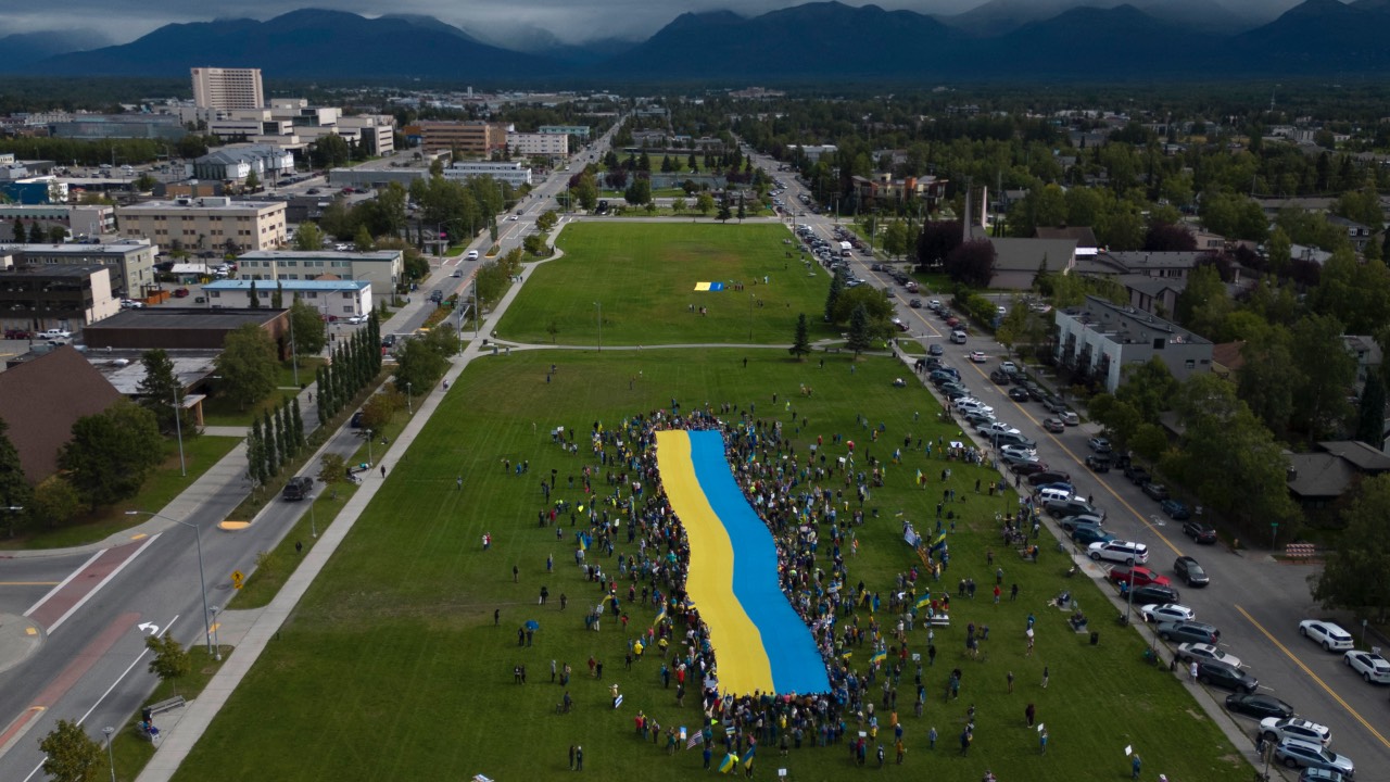 Protesters holding a giant Ukrainian flag in Anchorage, Alaska, during the U.S.-Russia summit at nearby Joint Base Elmendorf-Richardson. /Daphne Lemelin/AFP