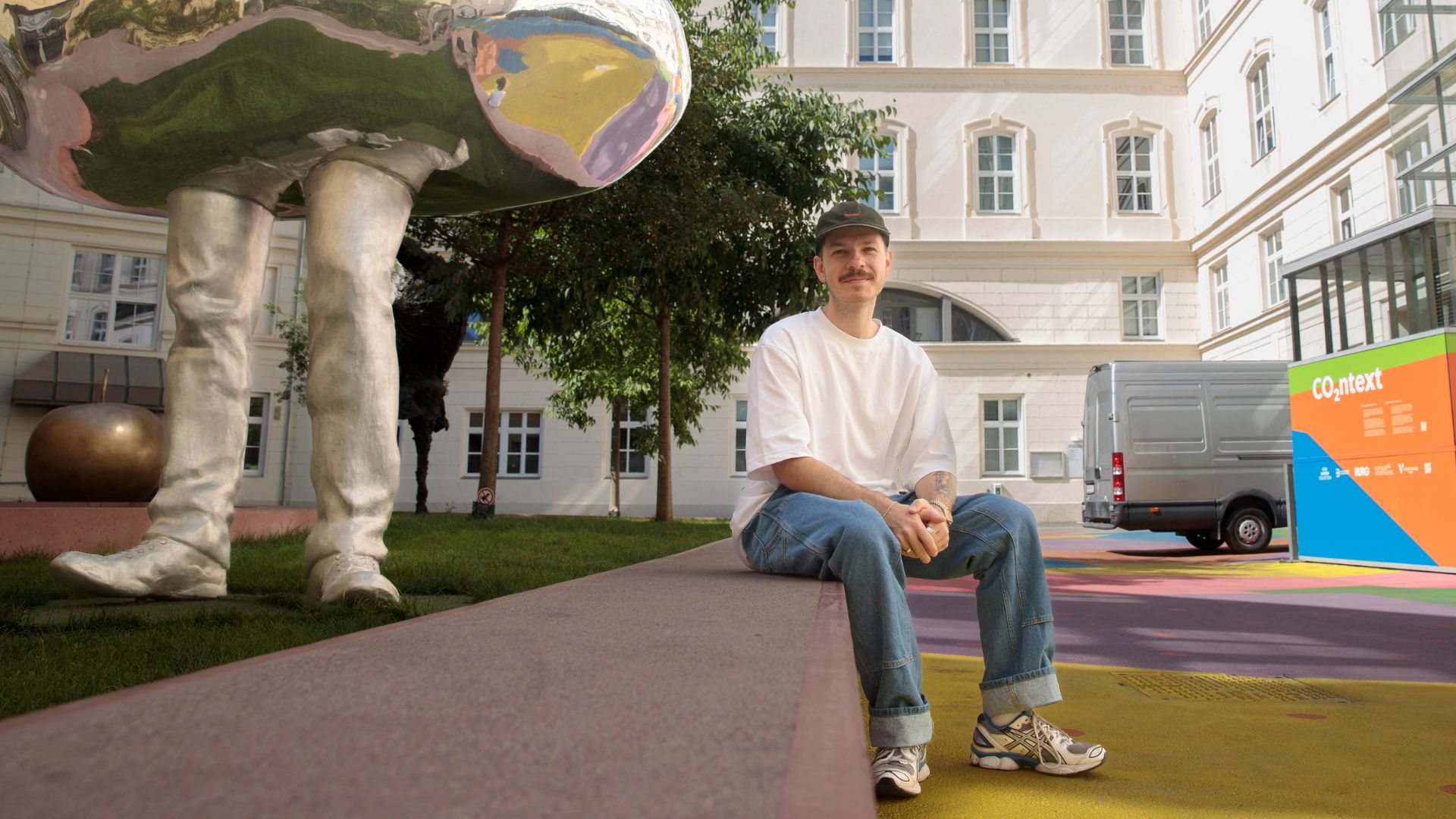 Member of artist group 'Holla Hoop' Jonas Griessler (R) poses for a picture as the colorfully painted courtyard of the 'Heidi Horten museum'. /Alex Halada/AFP

