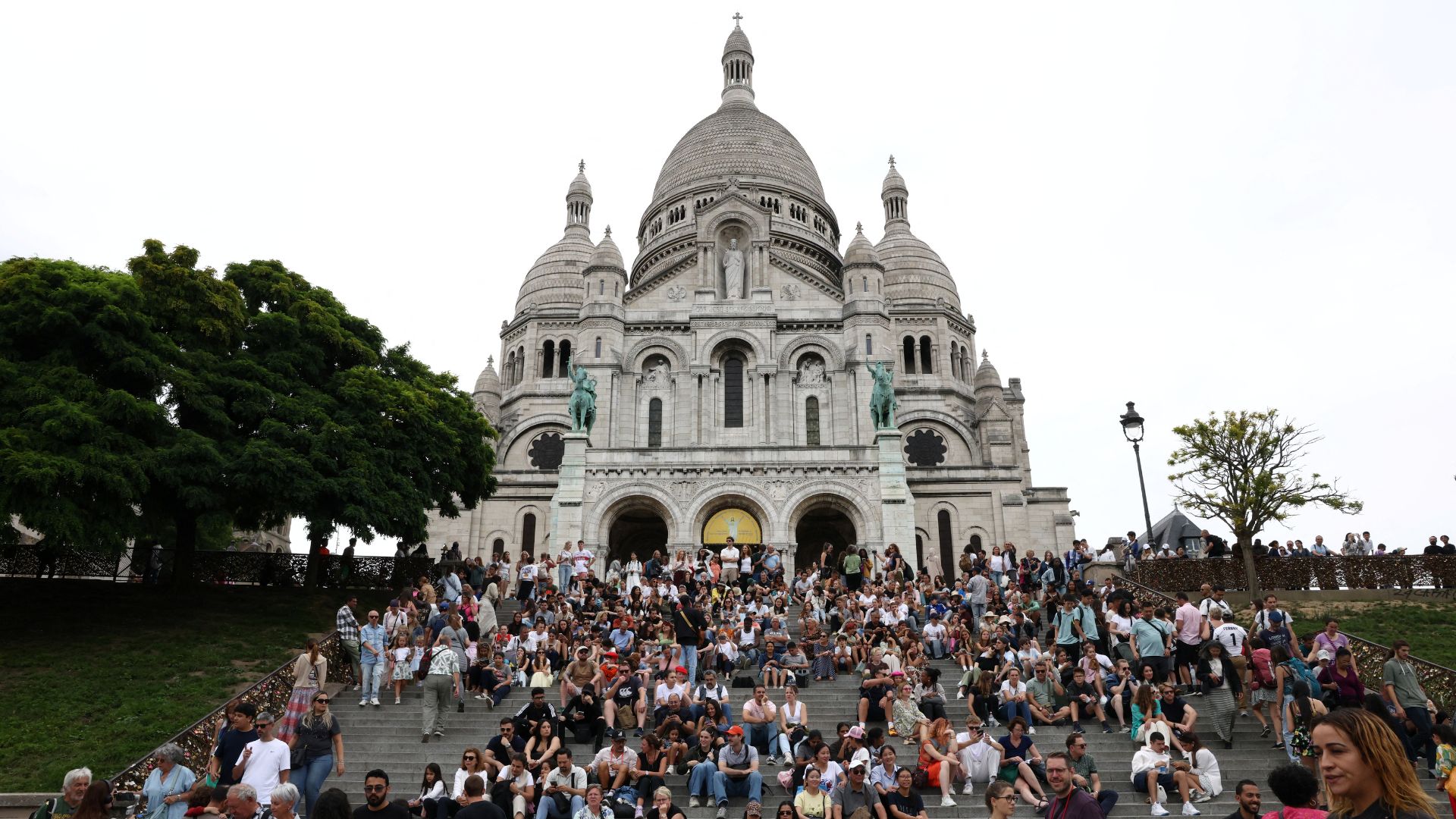 Tourists sit on the steps outside the Sacre-Coeur Basilica in Montmartre. /Tom Nicholson/Reuters
