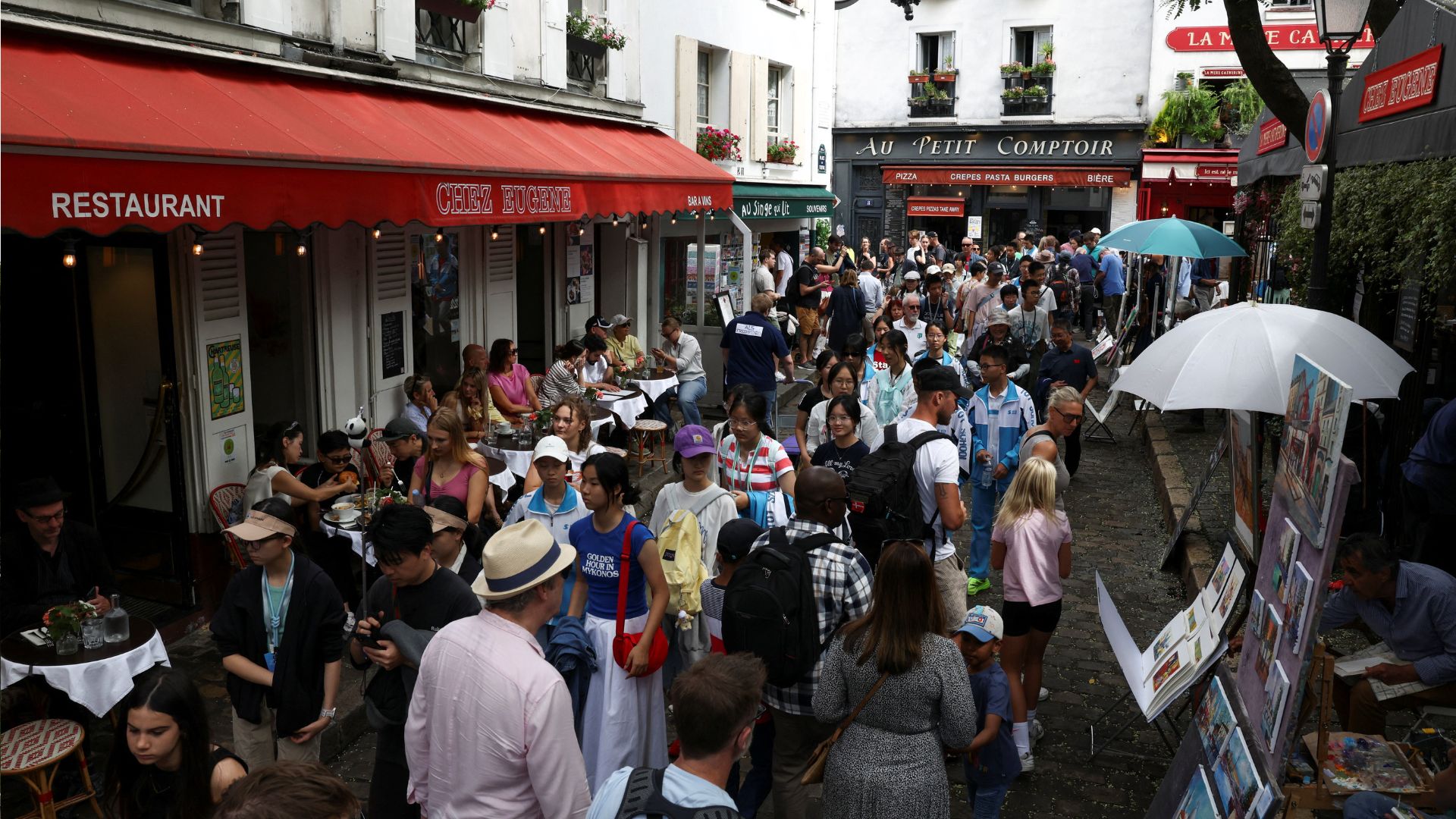 Tourists walk through crowded streets of the Place du Tertre in Montmartre. /Tom Nicholson/Reuters
