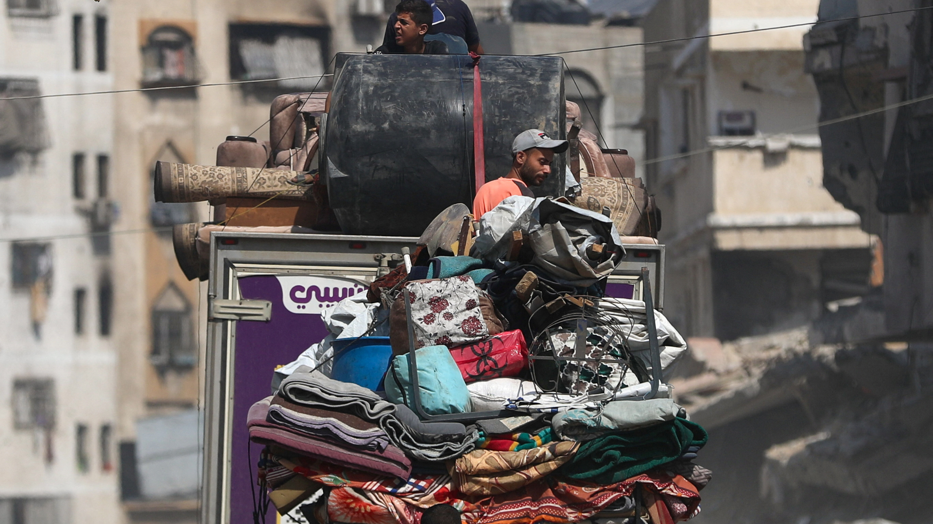 Displaced Palestinians sit on vehicles with their luggage as they flee following an Israeli evacuation order, in Gaza City. /Mahmoud Issa/Reuters