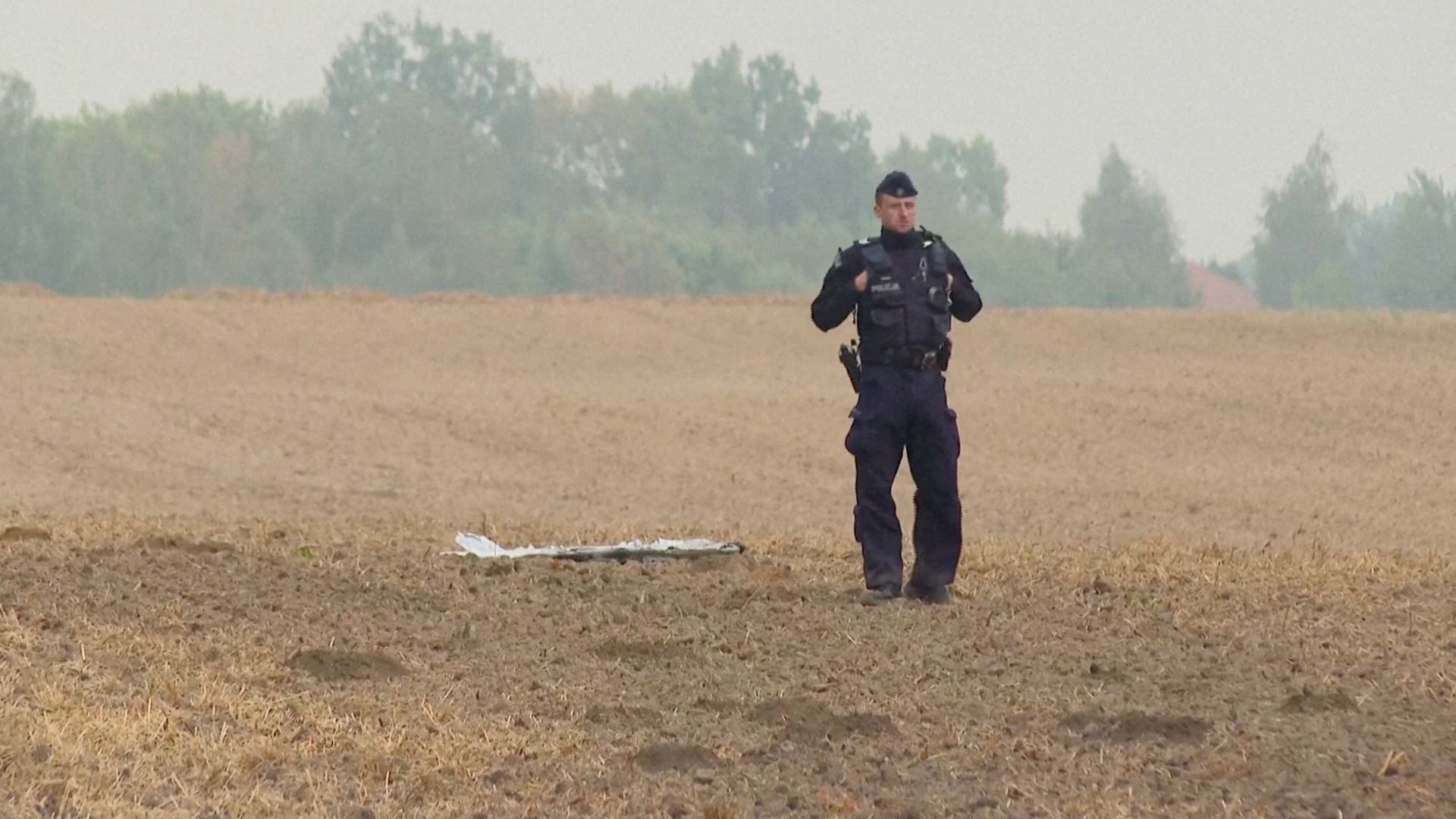 A Polish police officer stands near a drone fragment in Czesniki, Lublin Voivodeship, Poland. /Polsat News via Reuters