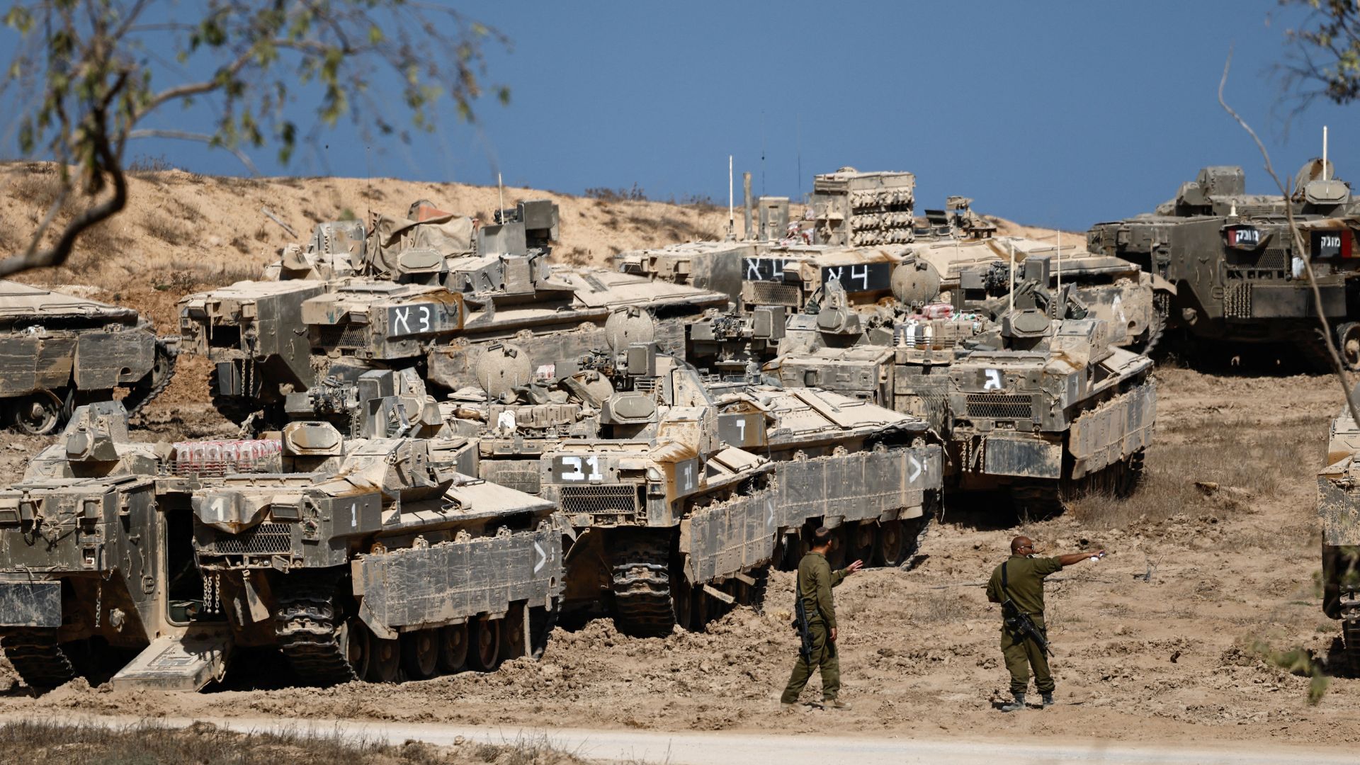 Israeli soldiers stand next to armoured personnel carriers (APCs) near the Israel-Gaza border, in Israel on September. /Amir Cohen/Reuters