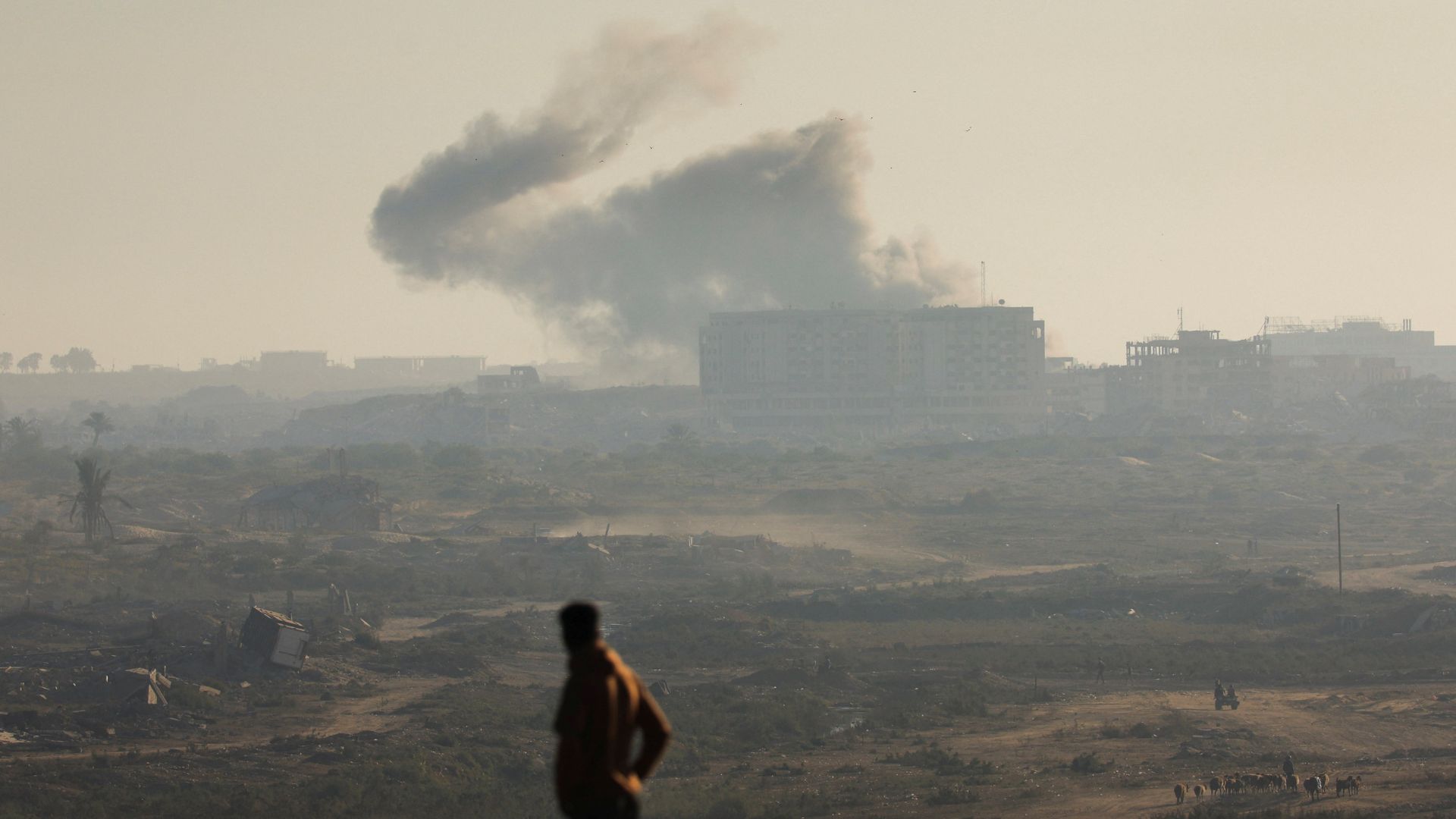 A man looks at smoke rising from an Israeli strike amid an Israeli operation, as seen from central Gaza Strip on September 20. /Dawoud Abu Alkas/Reuters
